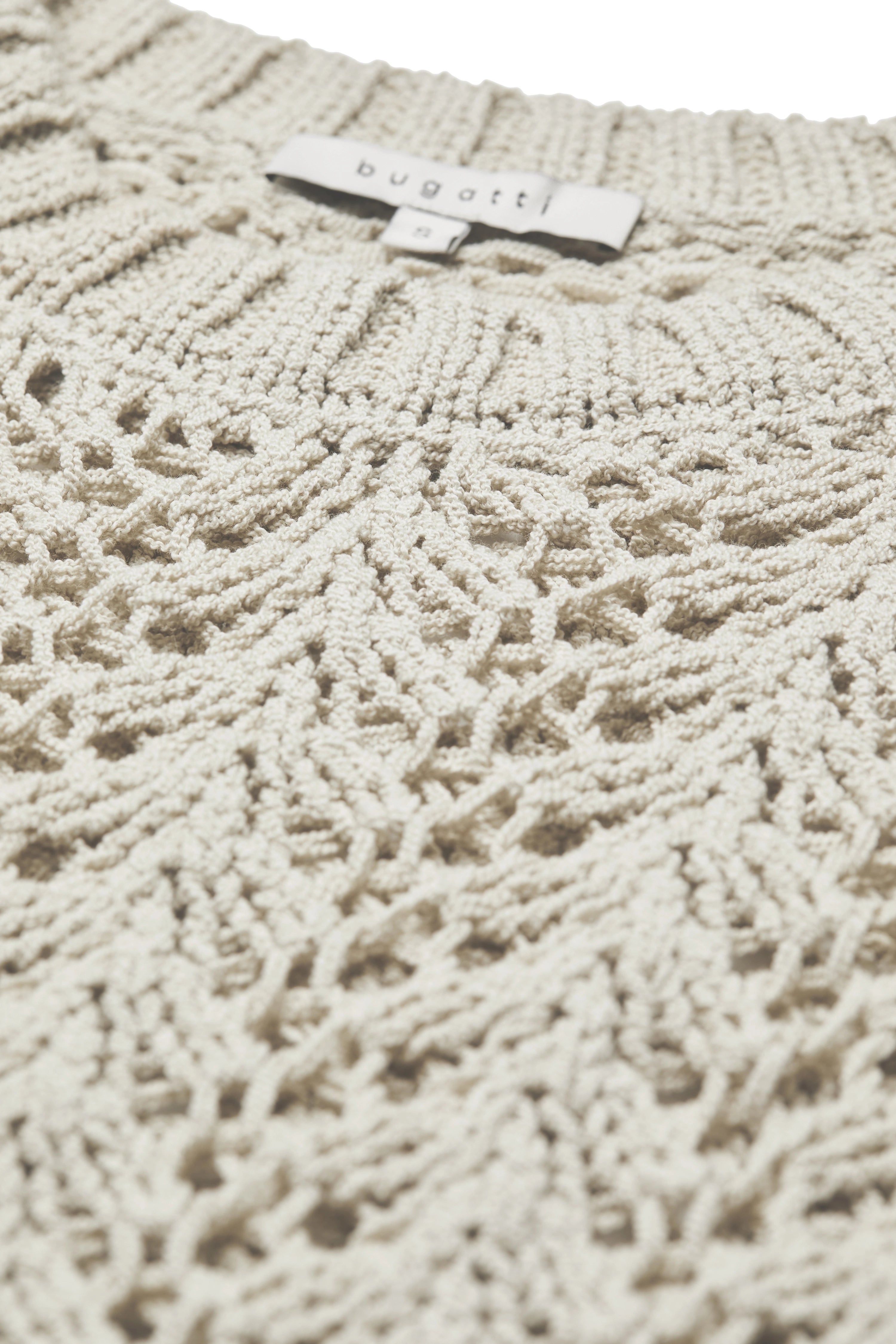 Beige bugatti trui met artistiek haakpatroon, detailopname.