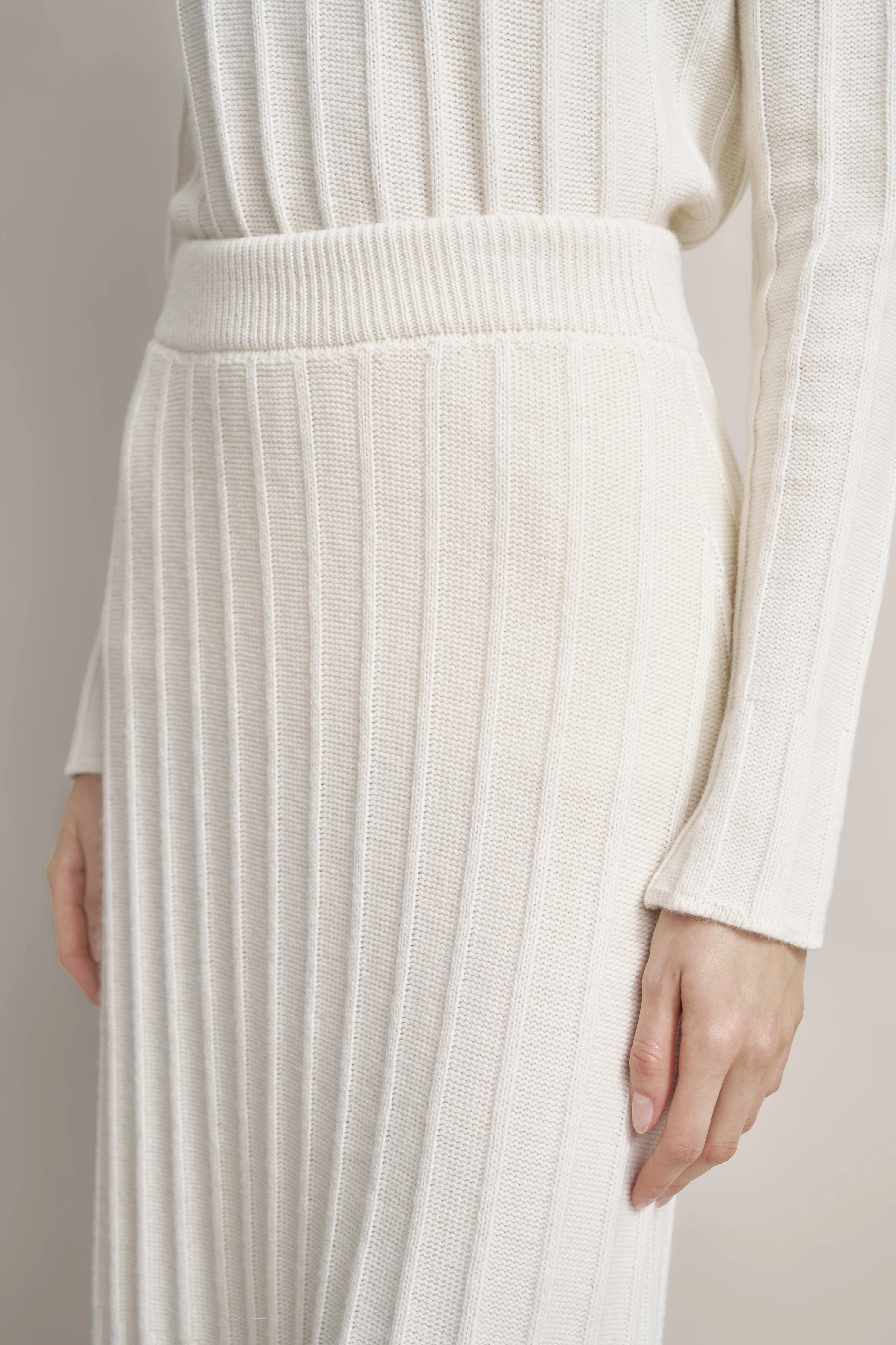 Strickkleid in Creme mit Rippstruktur, Detailaufnahme, langer Ärmel, bugatti Stil und Eleganz.