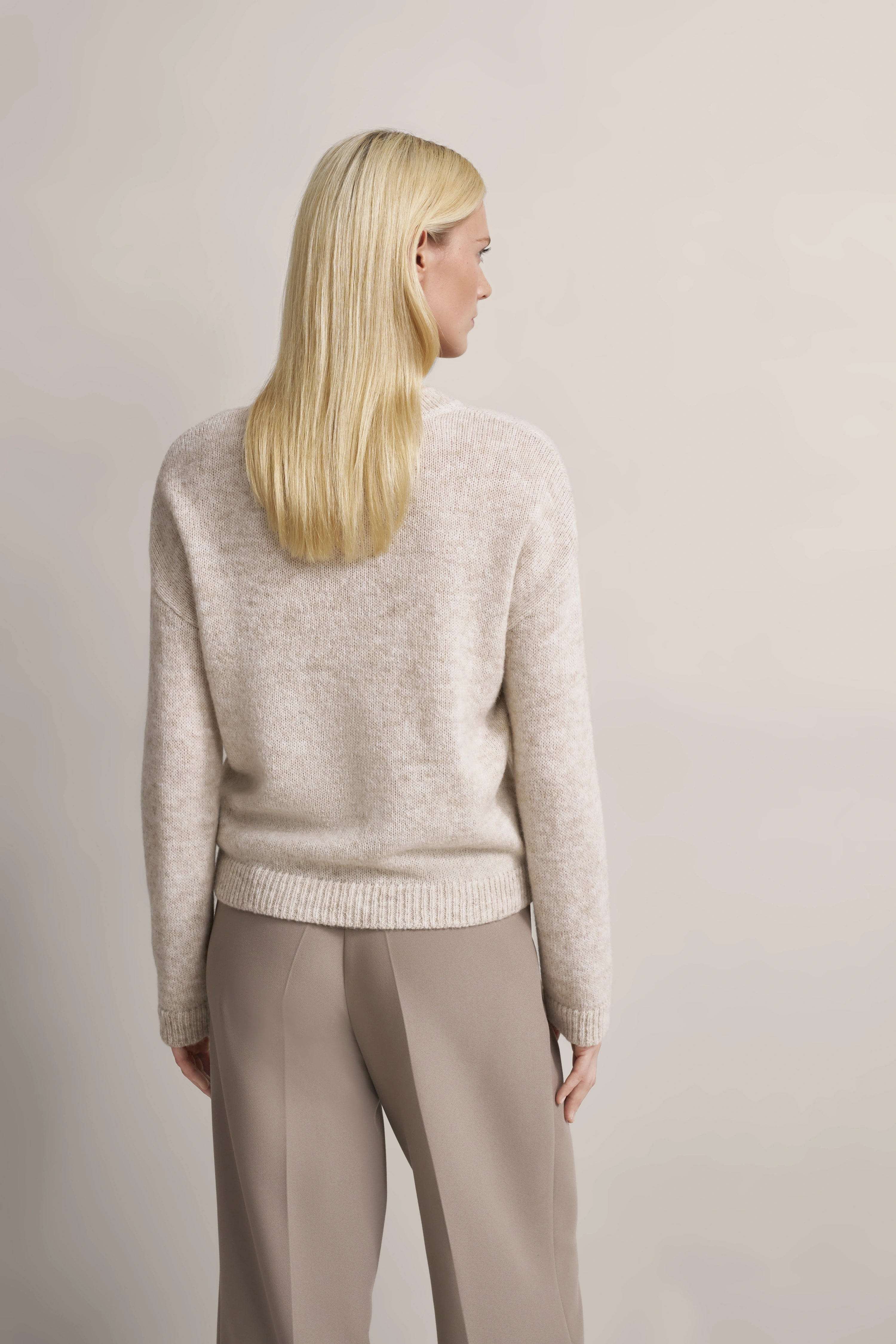 Beige Pullover und taupe Hose von bugatti, Modelbild von hinten, entspannte Pose.