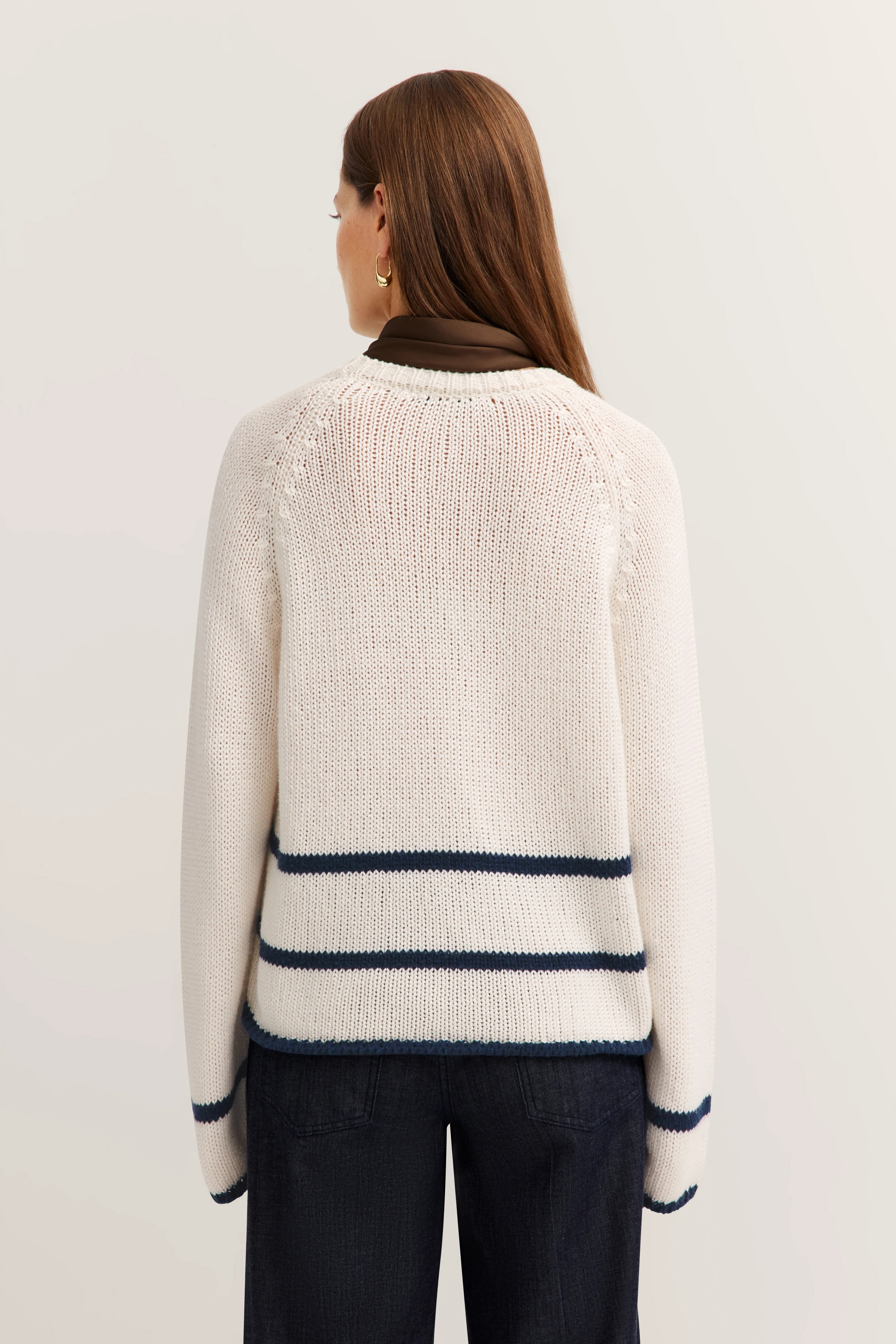 Weißer Strickpullover mit blauen Streifen, Modelbild von hinten.