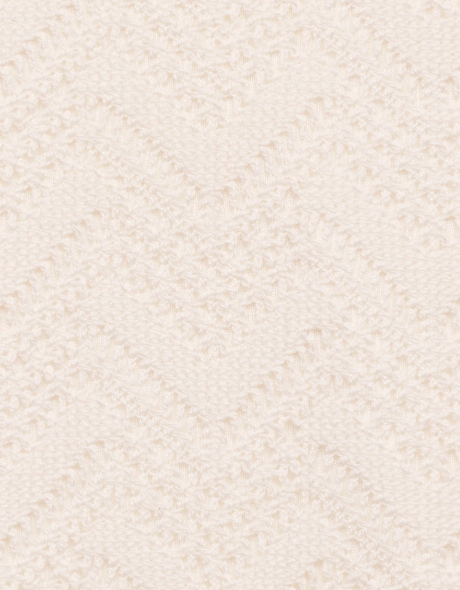 Strickstoff in Cremeweiß mit Zickzackmuster, Detailaufnahme.