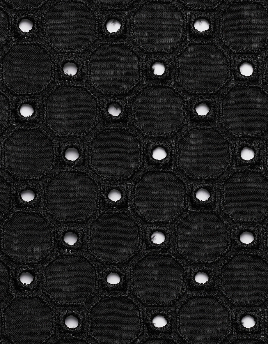 Schwarzer Stoff mit geometrischem, durchbrochenem Muster, Detailaufnahme.