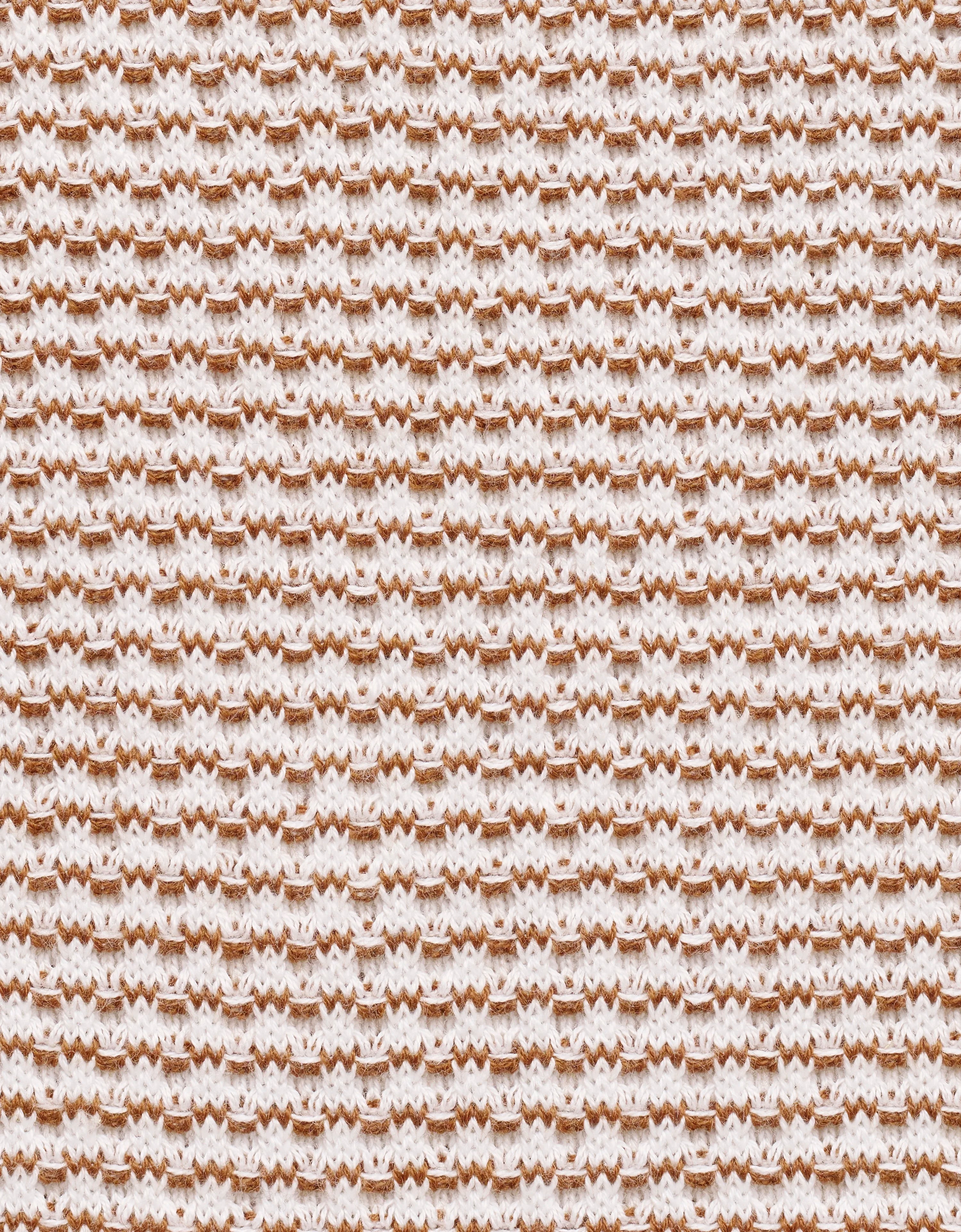 Gestricktes Muster in Weiß und Braun, Nahaufnahme, Texturdetail, zeigt hochwertige Verarbeitung.
