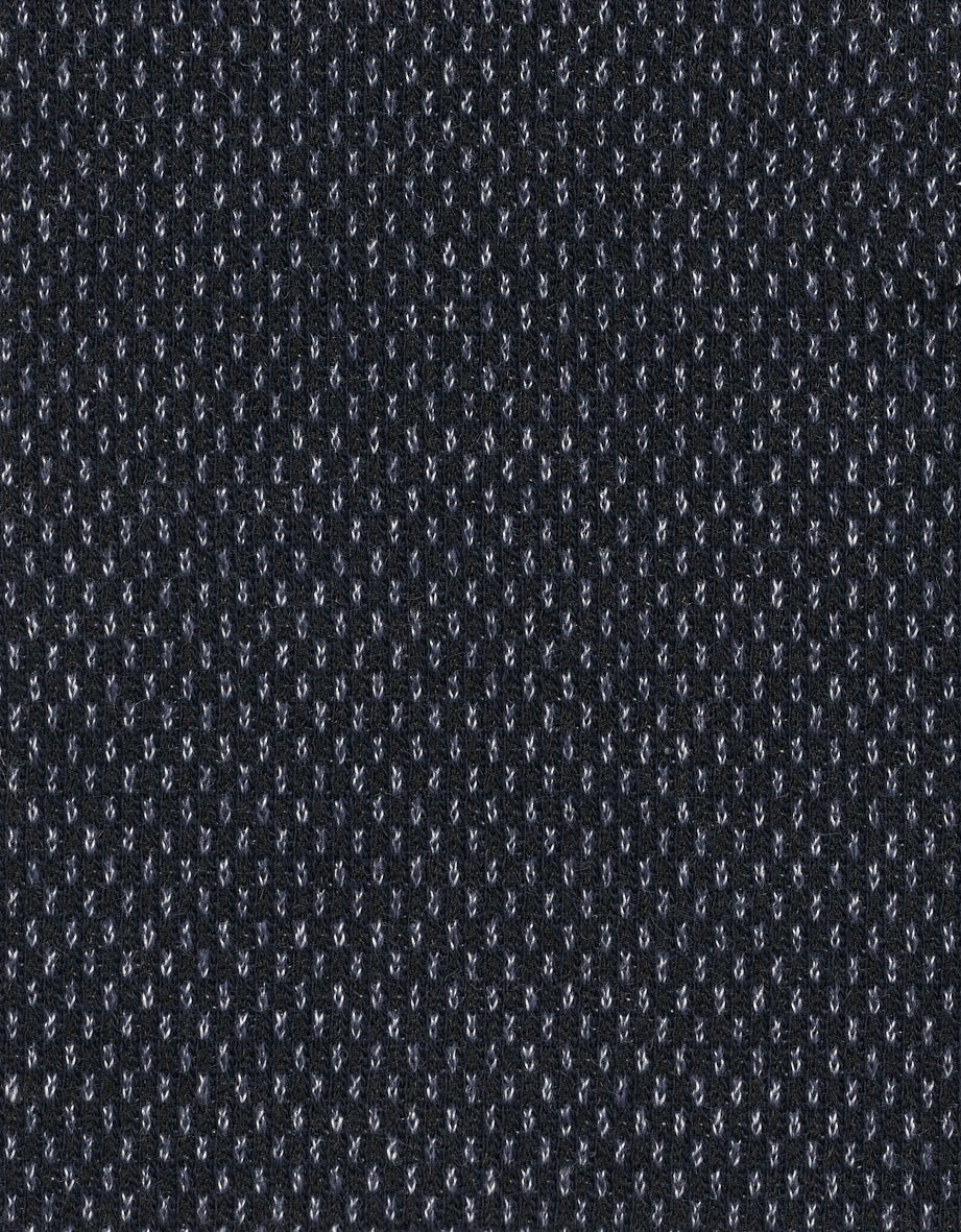 Schwarzer Strickstoff mit feinem, weißen Punktmuster, Detailaufnahme.