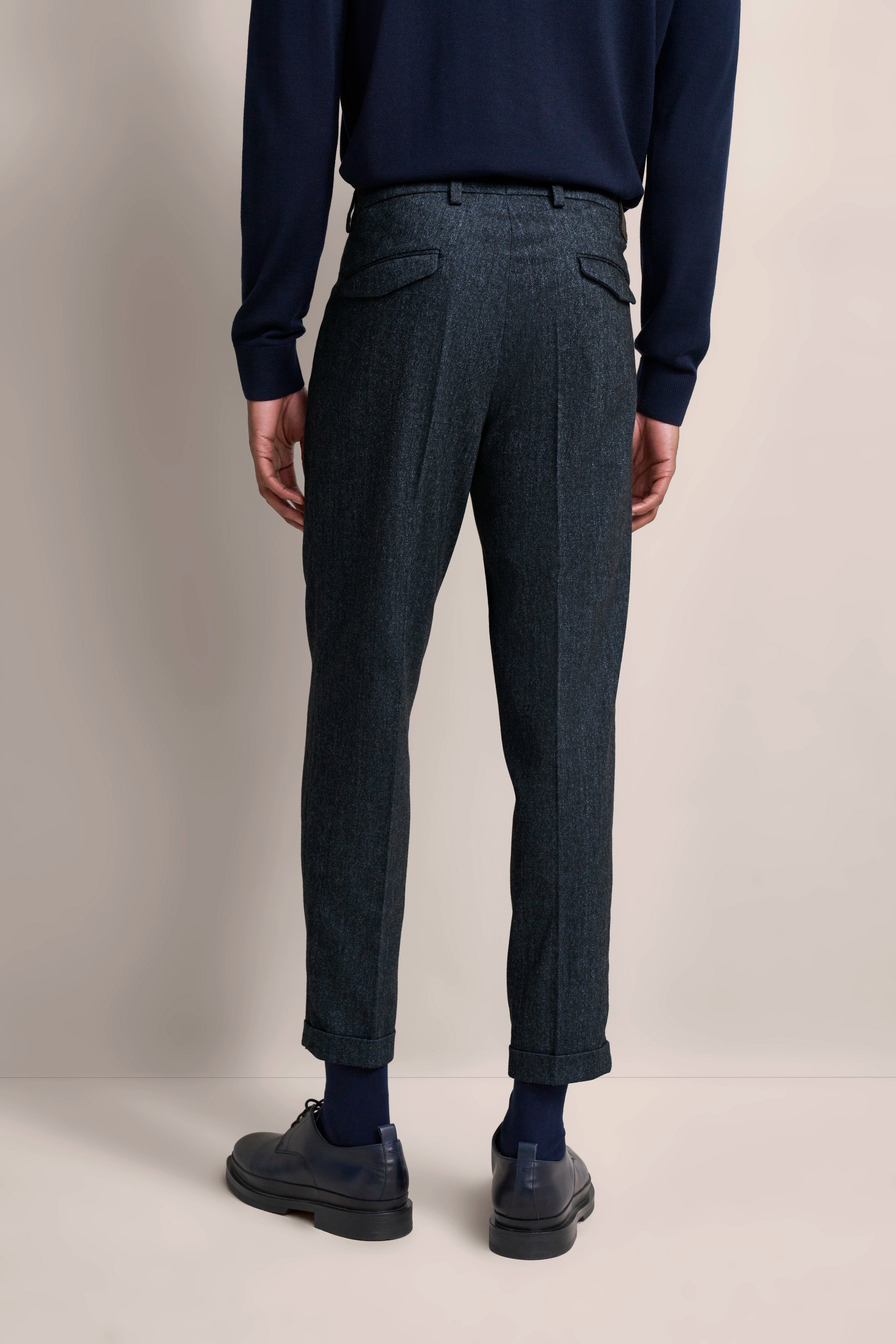 bugatti Herren-Look: Dunkelblauer Pullover, graue Anzughose, Model von hinten.