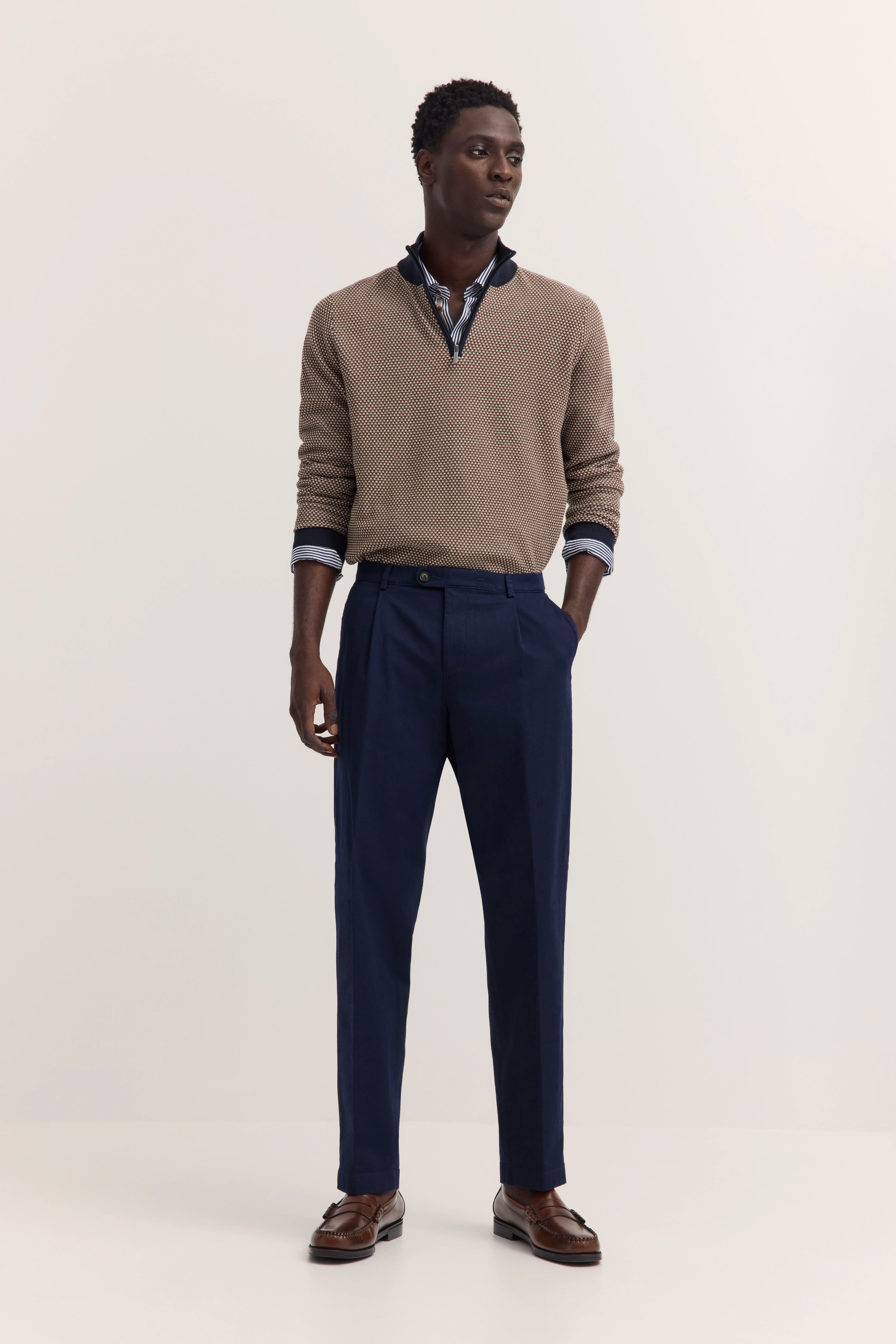 Model in braunem Pullover, blauem Hemd und dunkelblauer Hose, legeres Pose, stilvoll von bugatti.