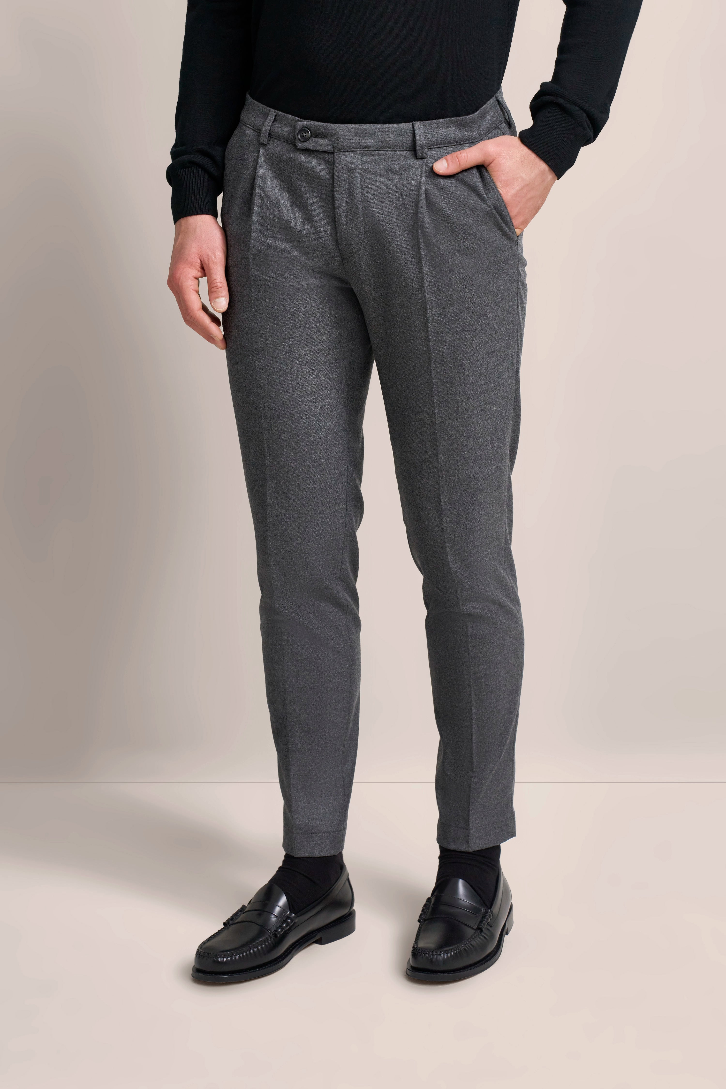Graue Hose und schwarzer Pullover von bugatti, eleganter Look, Büstenbild mit Hand in Tasche.