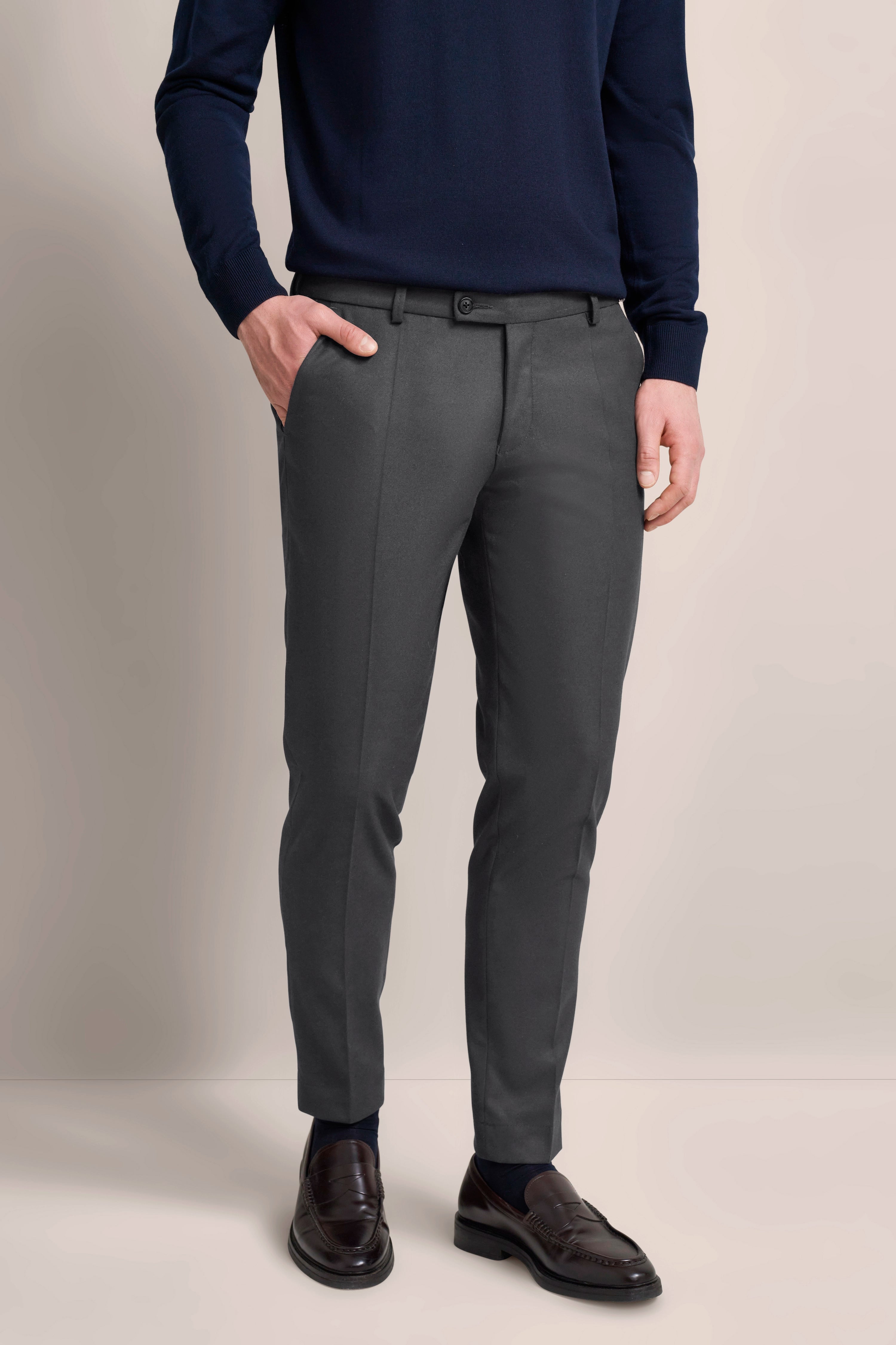 Navy sweater and gray pants by bugatti, model image, hands in pockets, relaxed pose.