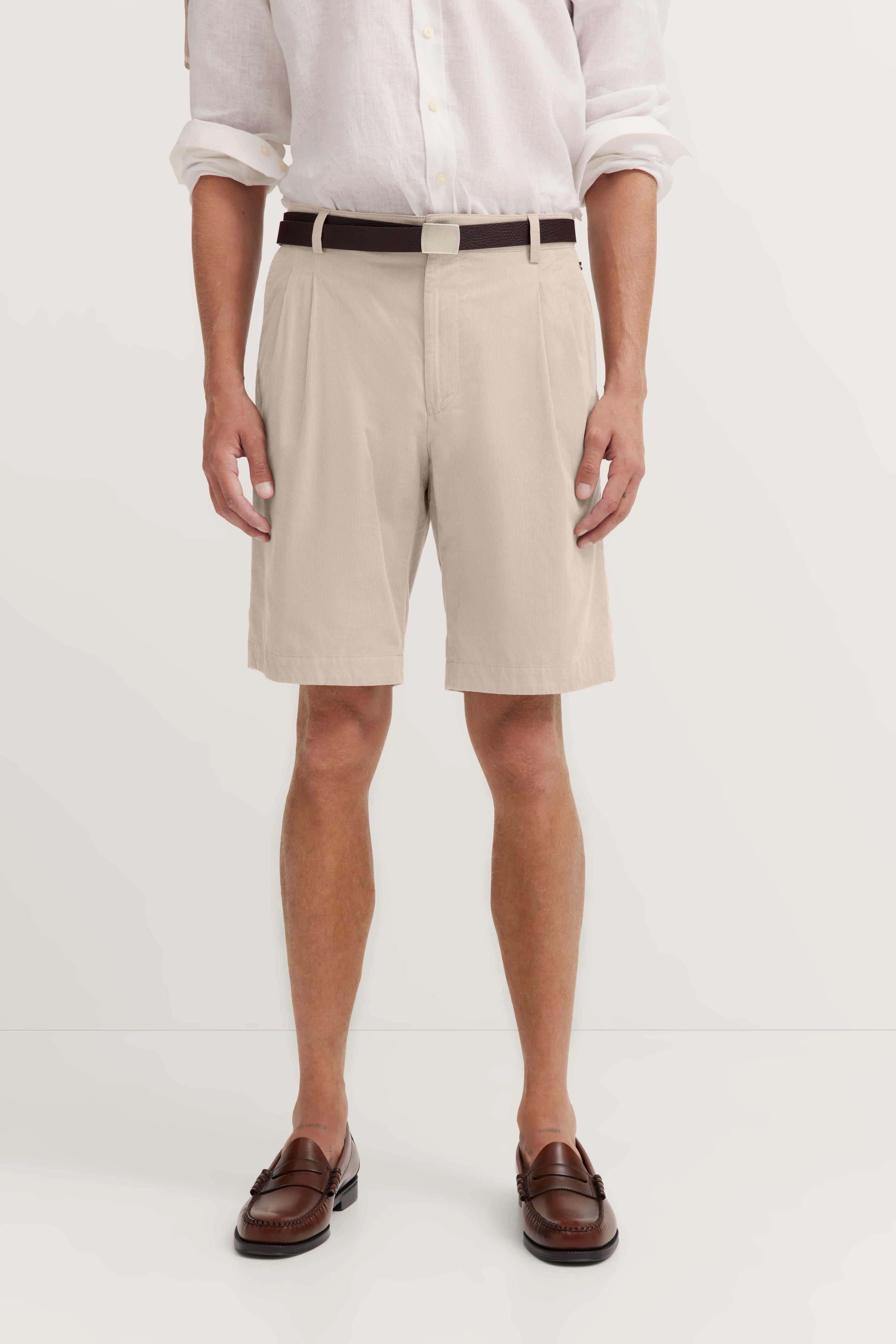 Beige Shorts und weißes Hemd, brauner Gürtel, braune Loafer