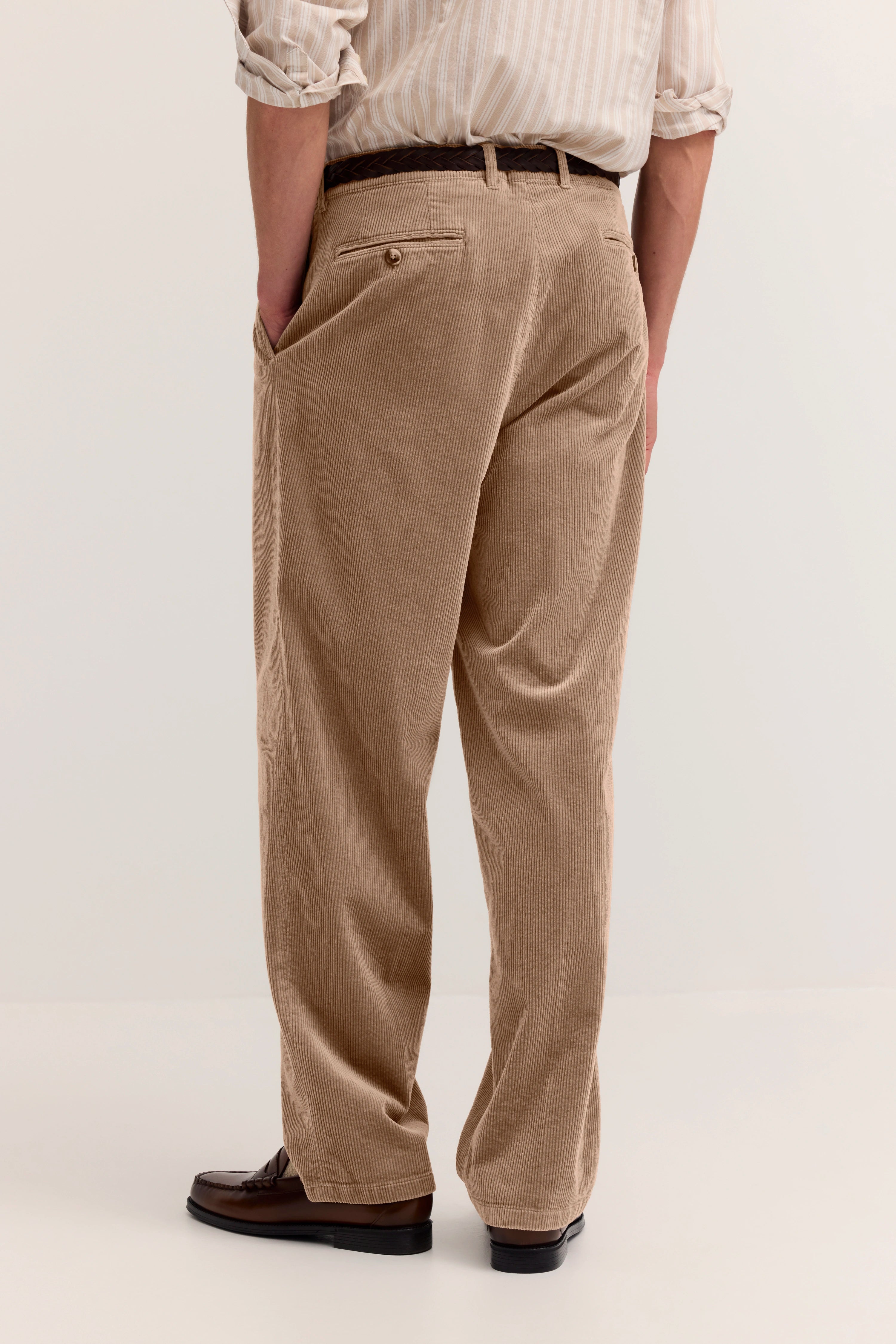 Beige Cordhose von bugatti, Modelbild von hinten, lässige Pose, braune Lederschuhe.