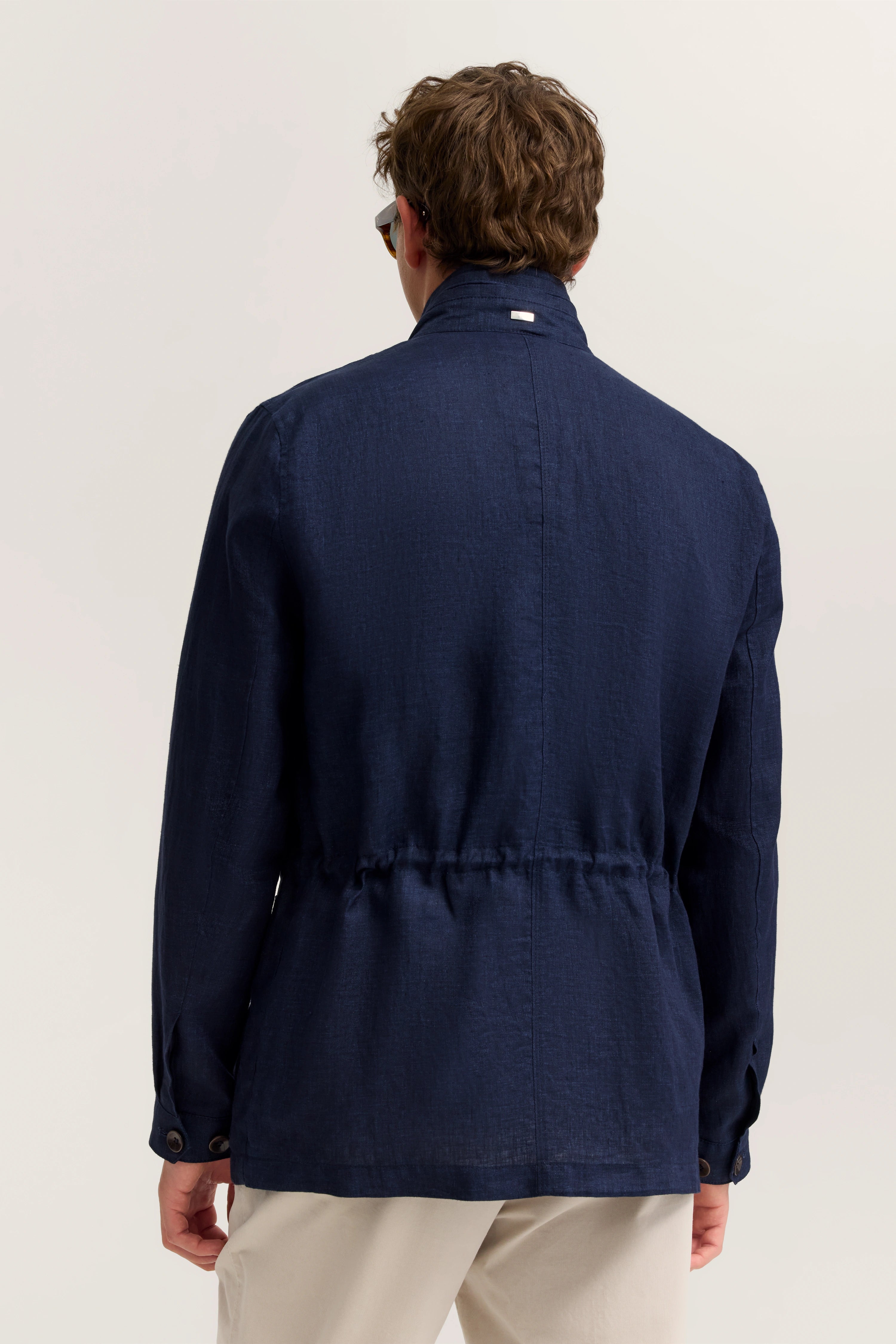 Dunkelblaue bugatti Jacke, legeres Modelbild, Rückansicht, entspannte Haltung, beige Hose.