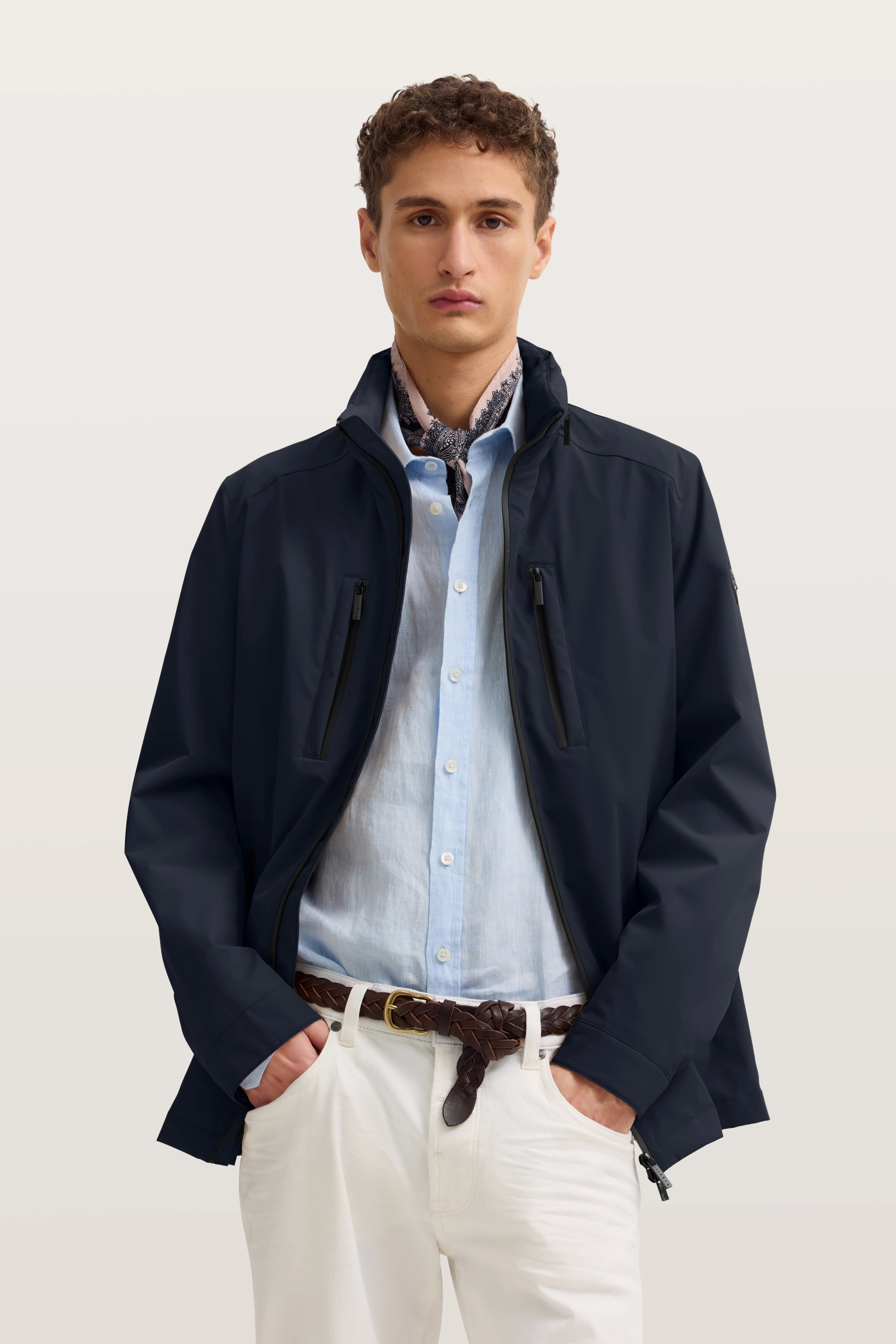 Model trägt blaue Jacke, hellblaues Hemd, weiße Hose, braunen Gürtel