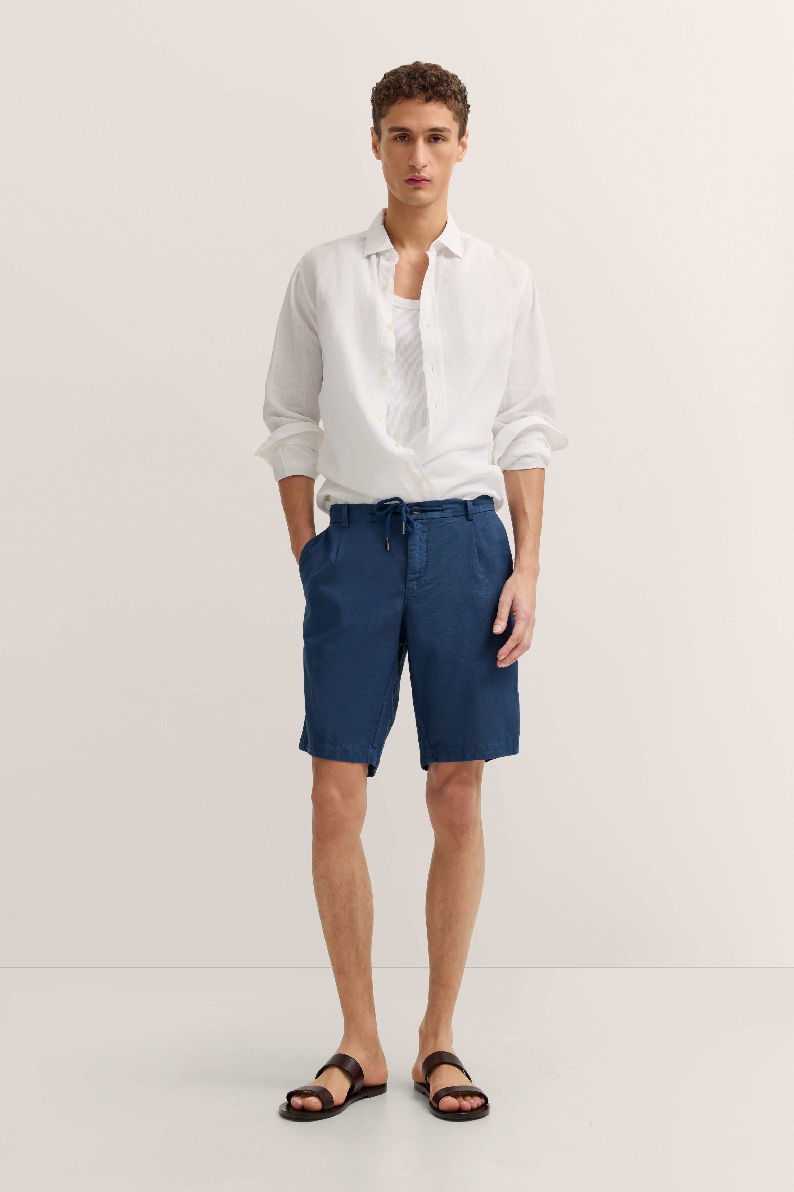 Weißes Hemd, blaue Shorts, legere Pose, Modelbild, bugatti Stil.