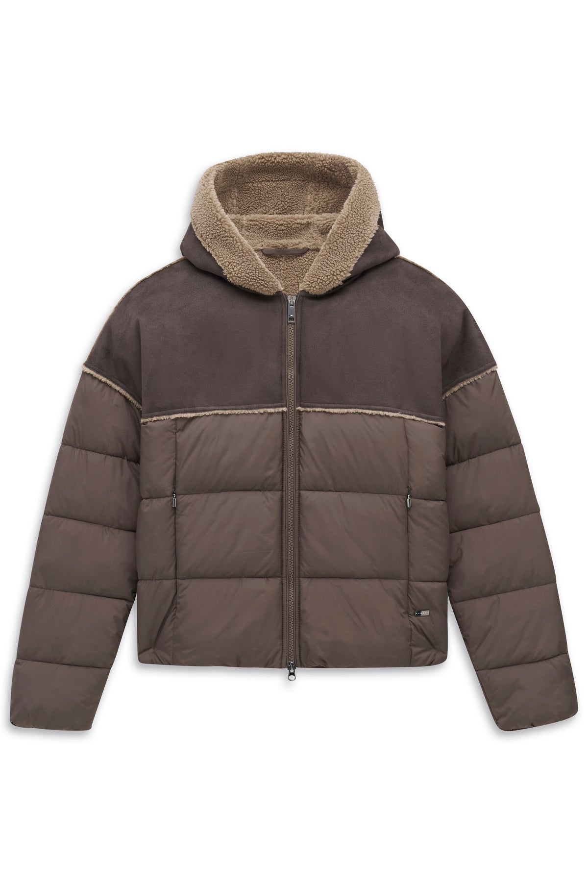 Model in brauner Steppjacke, grauer Hose, Hemd und Mokassins. Frontale Pose.