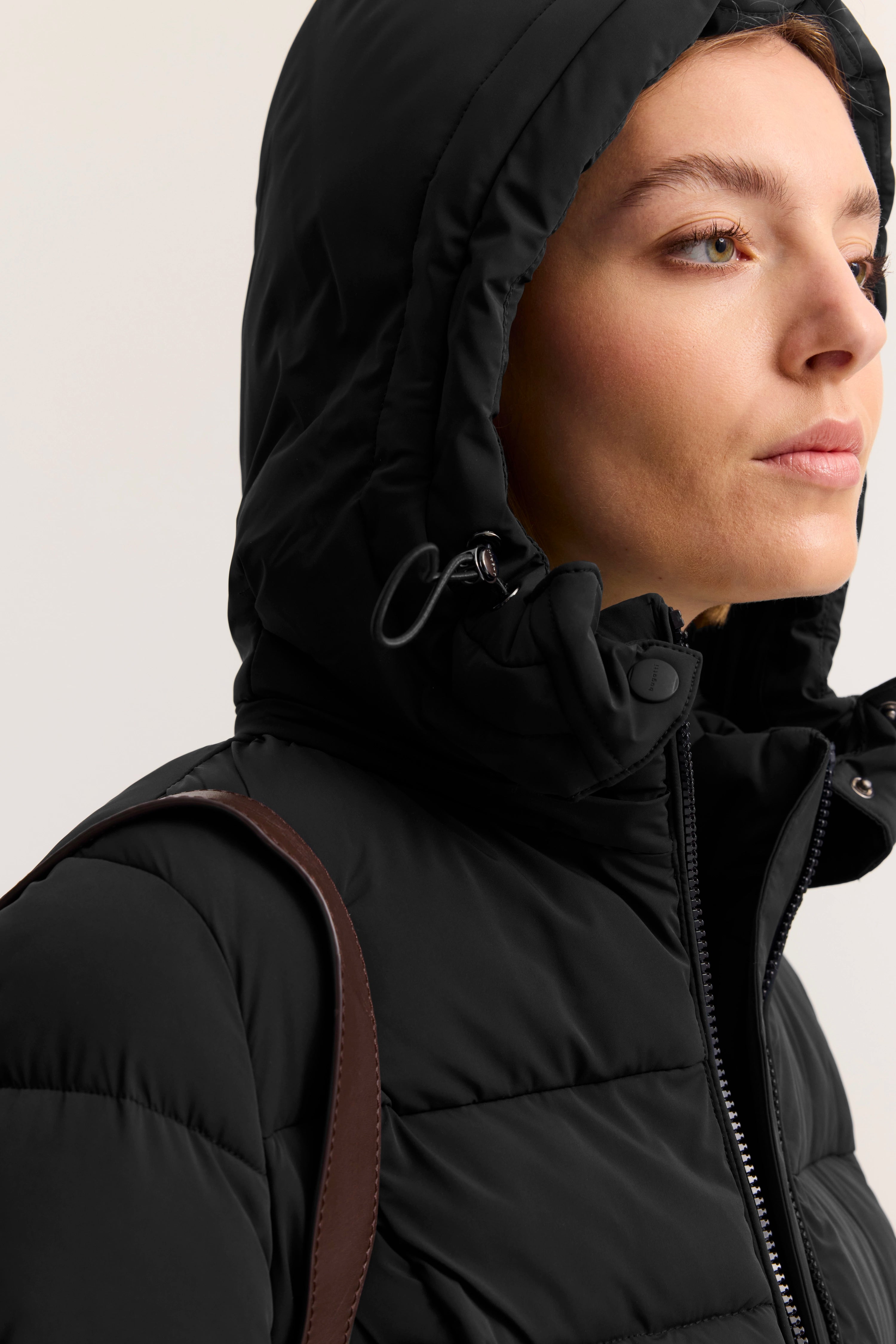 Schwarze bugatti Steppjacke mit Kapuze, Model seitlich, Detailansicht.