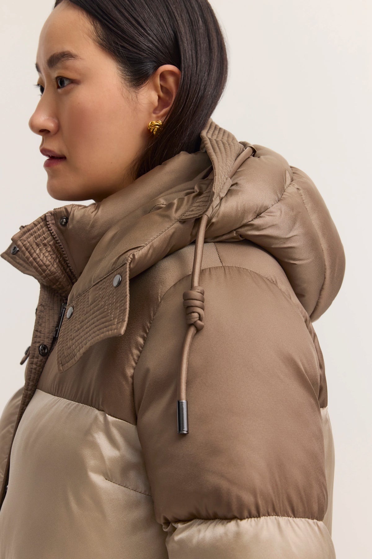 Braune und beige Steppjacke im Profil, Modelbild.