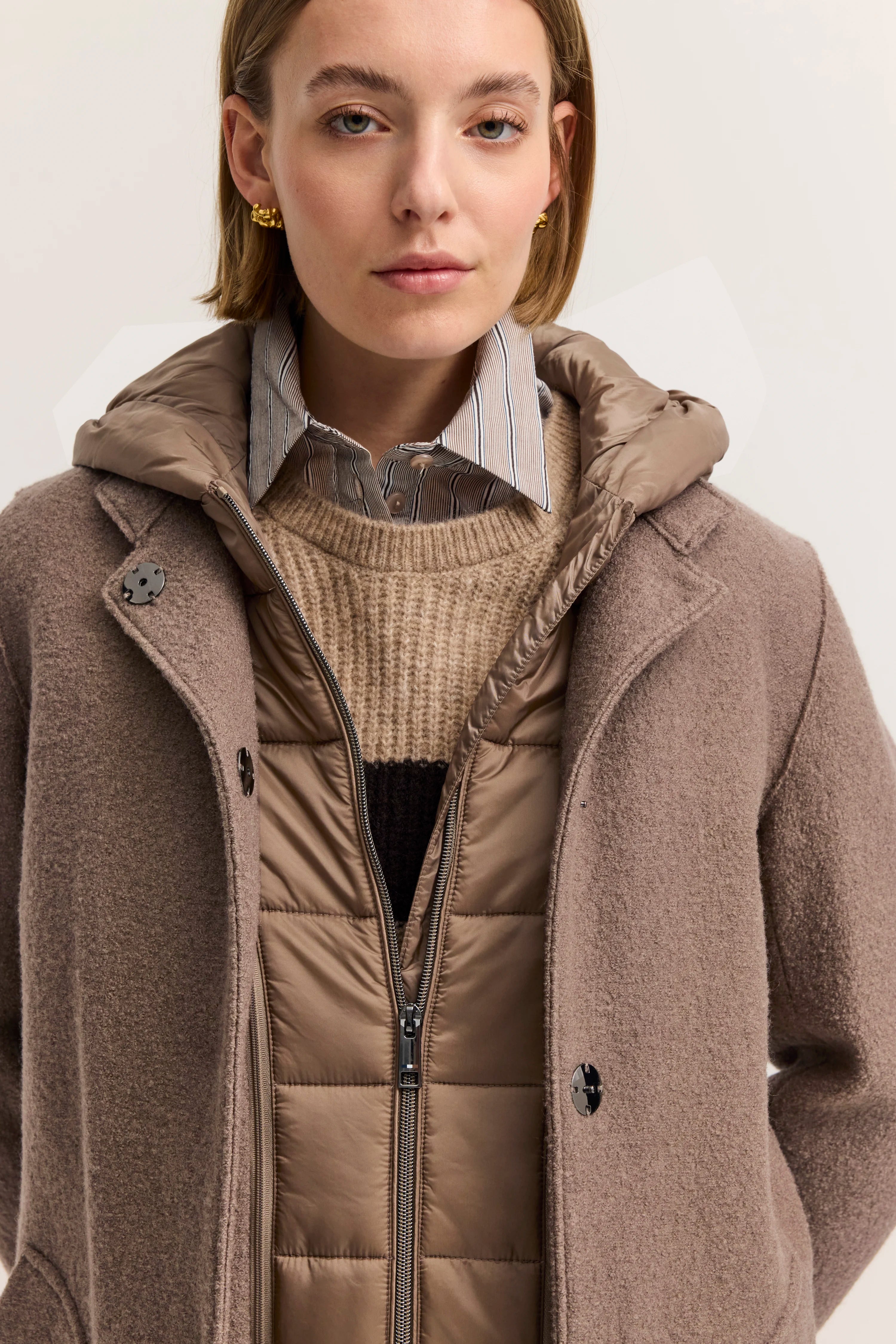 Damenmantel in Taupe, Rückansicht, mit Kapuze. Modelbild, neutral stehend.