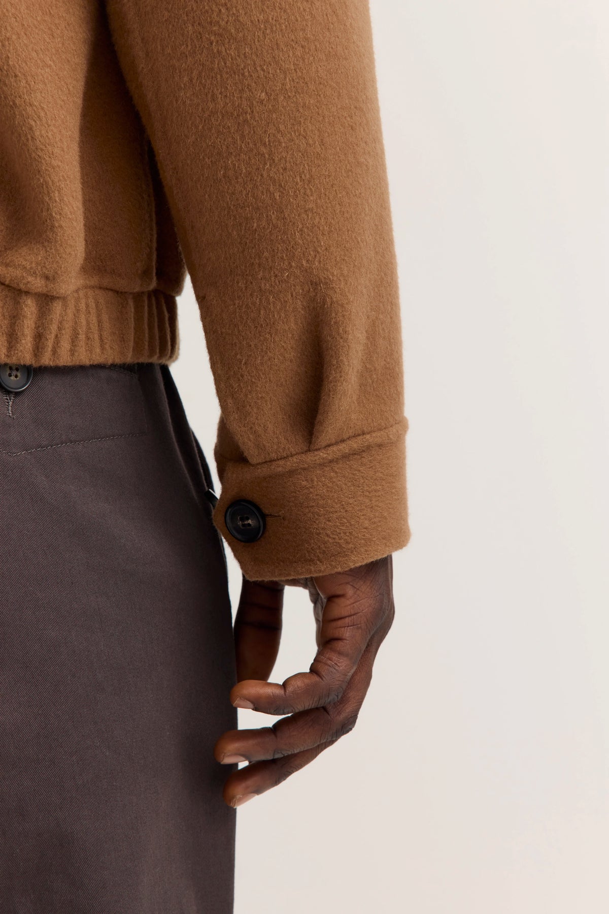 Braune Jacke von bugatti, Rückansicht auf Model, entspanntes Posing, kombiniert mit dunkler Hose.