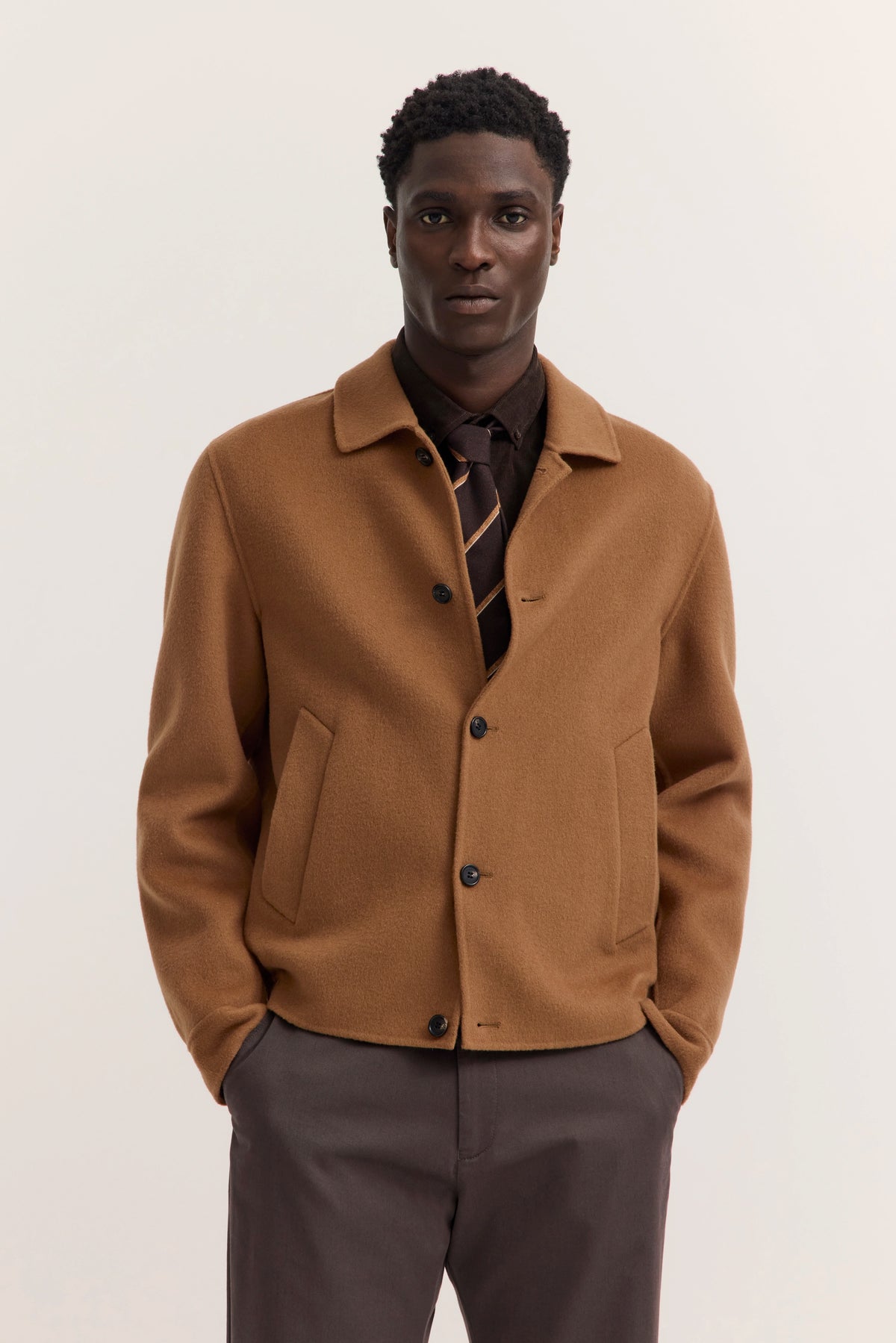 Modelbild mit camelbrauner Jacke und braunem Hemd, Krawatte