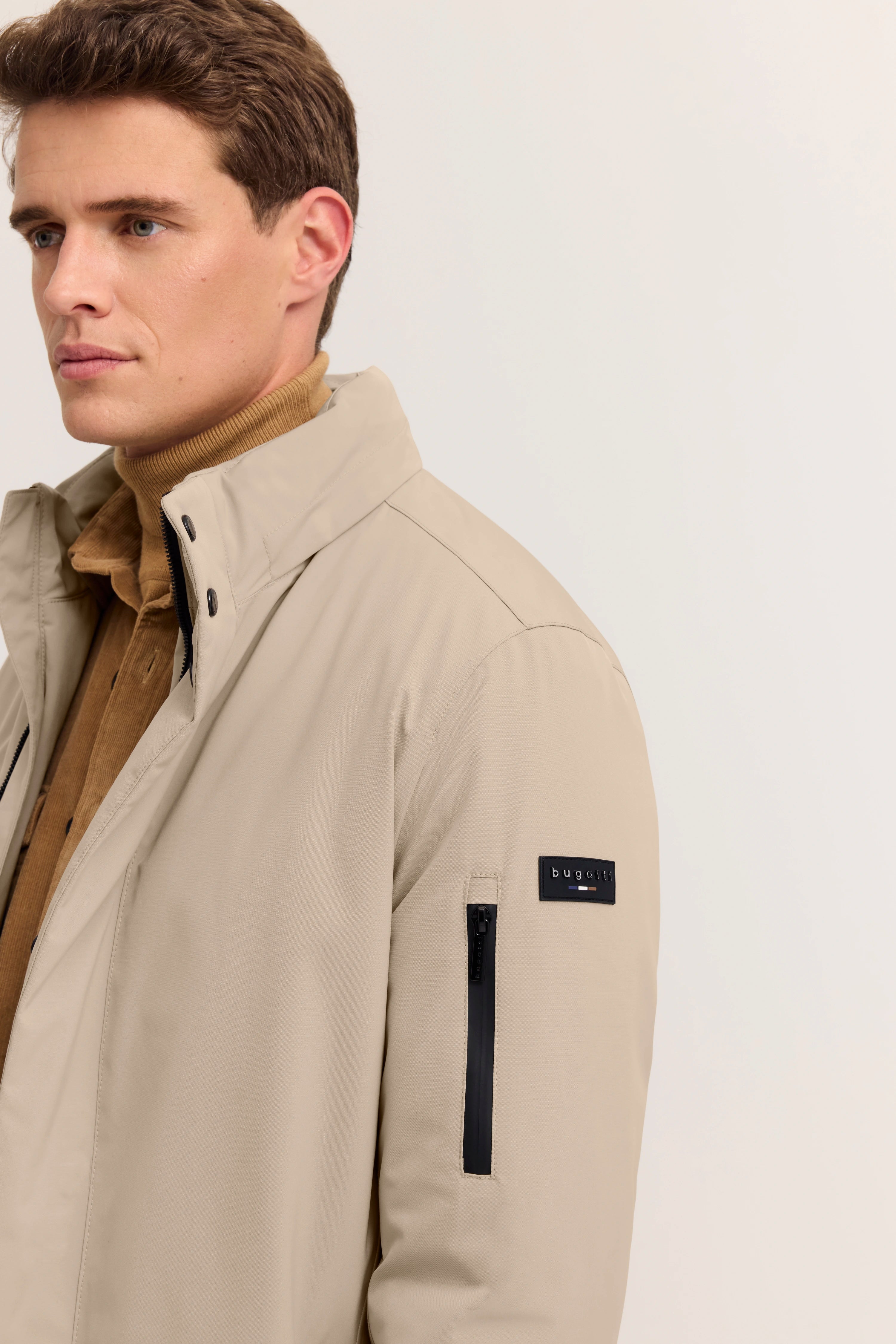 Beige bugatti Jacke mit Stehkragen, brauner Rollkragenpullover, Modelbild, Seitenansicht.