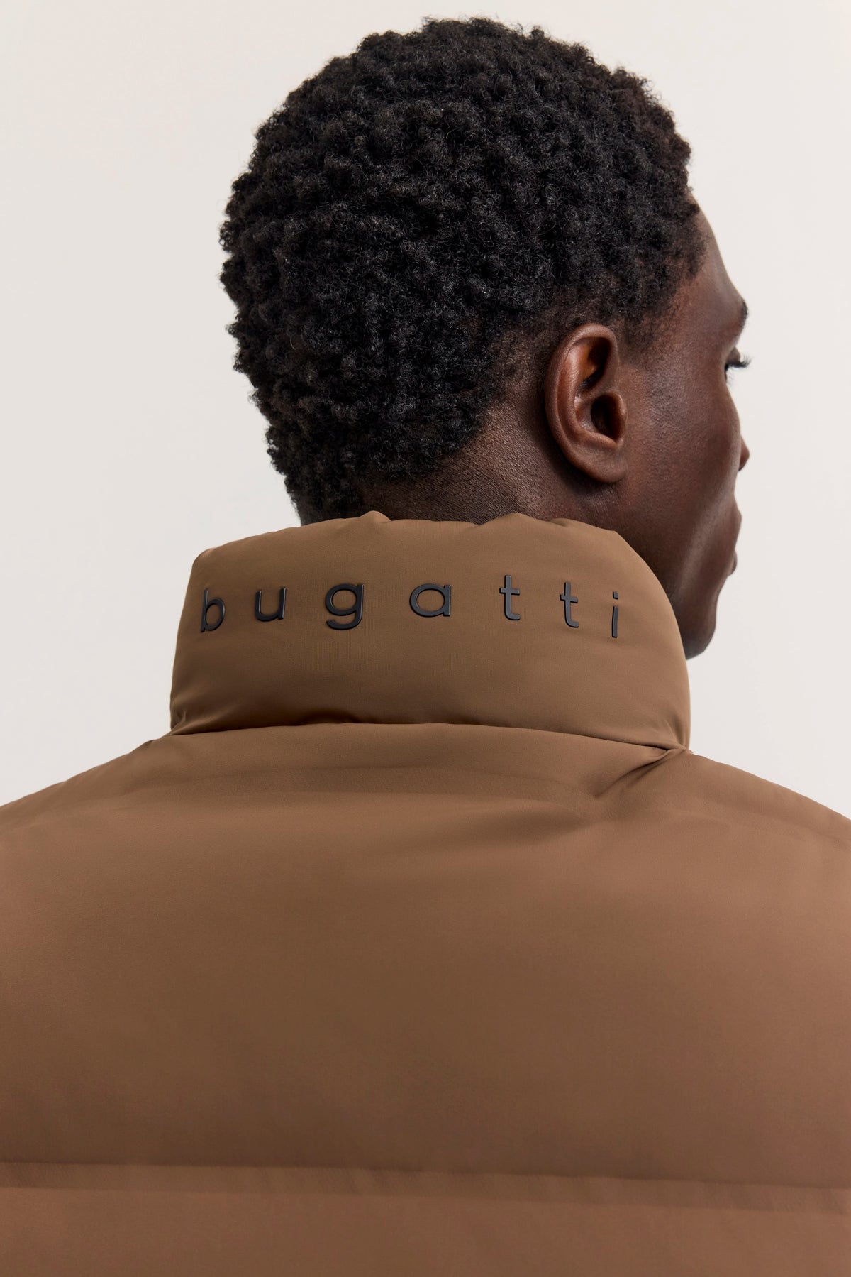 Braune bugatti-Jacke, Nahaufnahme des Rückens mit Logo, Büstenbild.