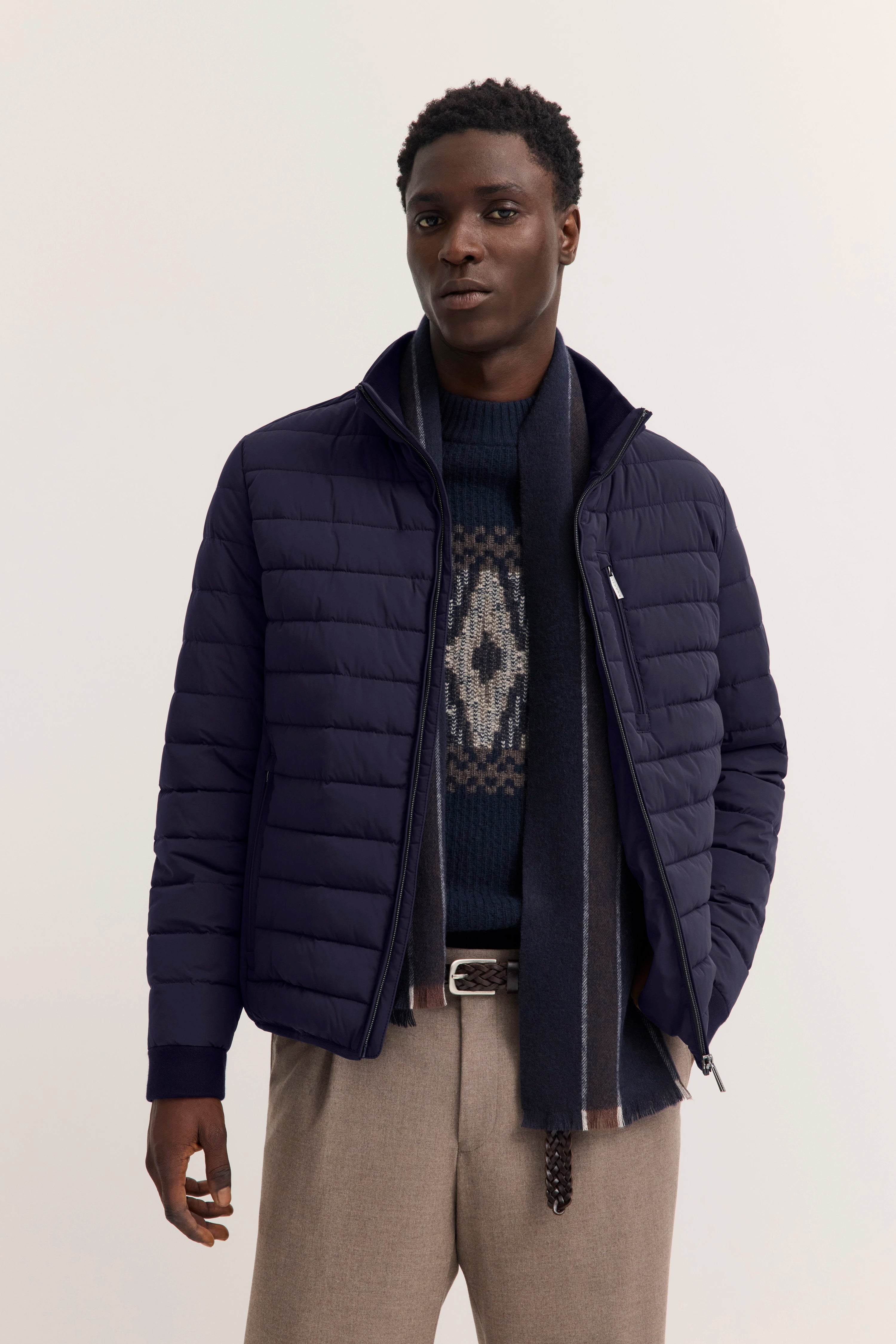 Navy Steppjacke, gemusterter Pullover, graue Hose