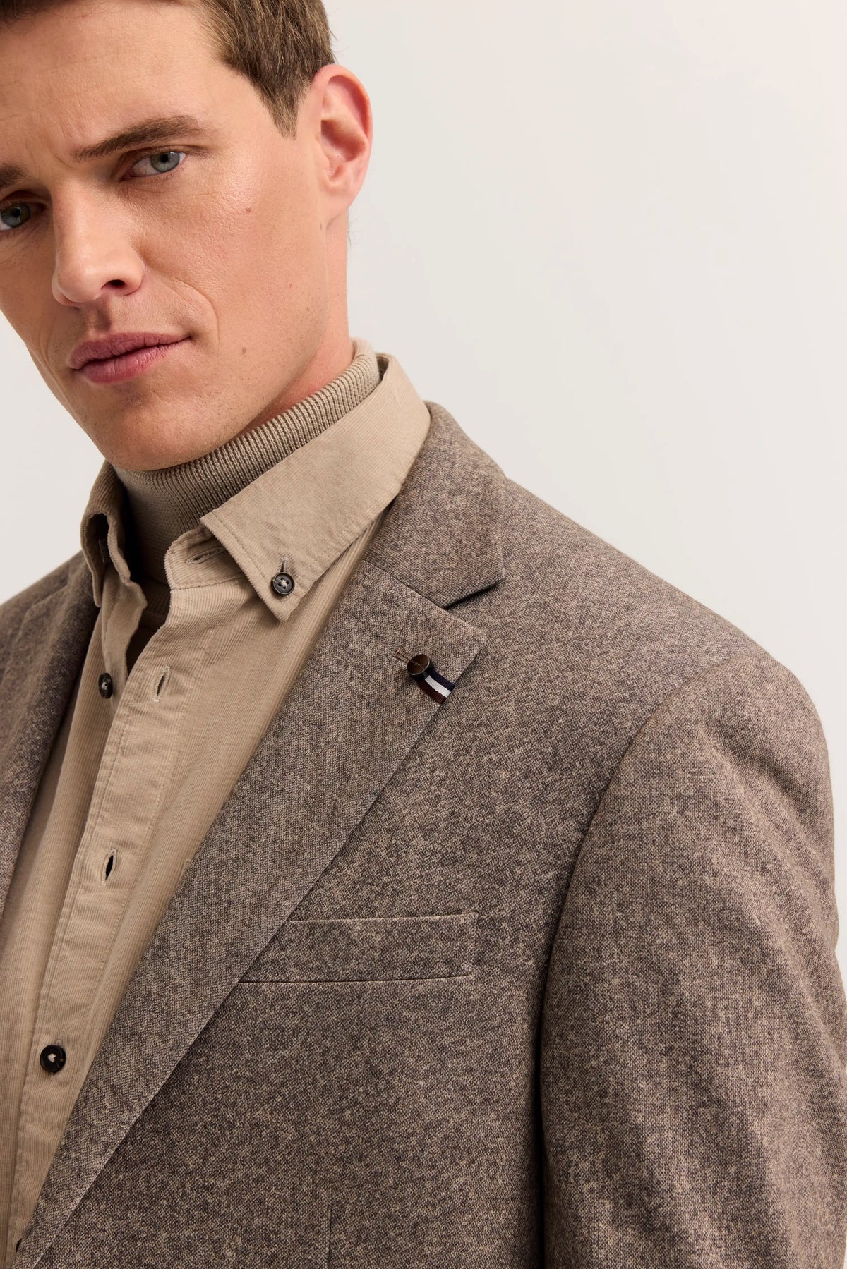 bugatti Herrenoutfit, Modelbild, beige Hemd und brauner Blazer, eleganter Look, dezente Posen.
