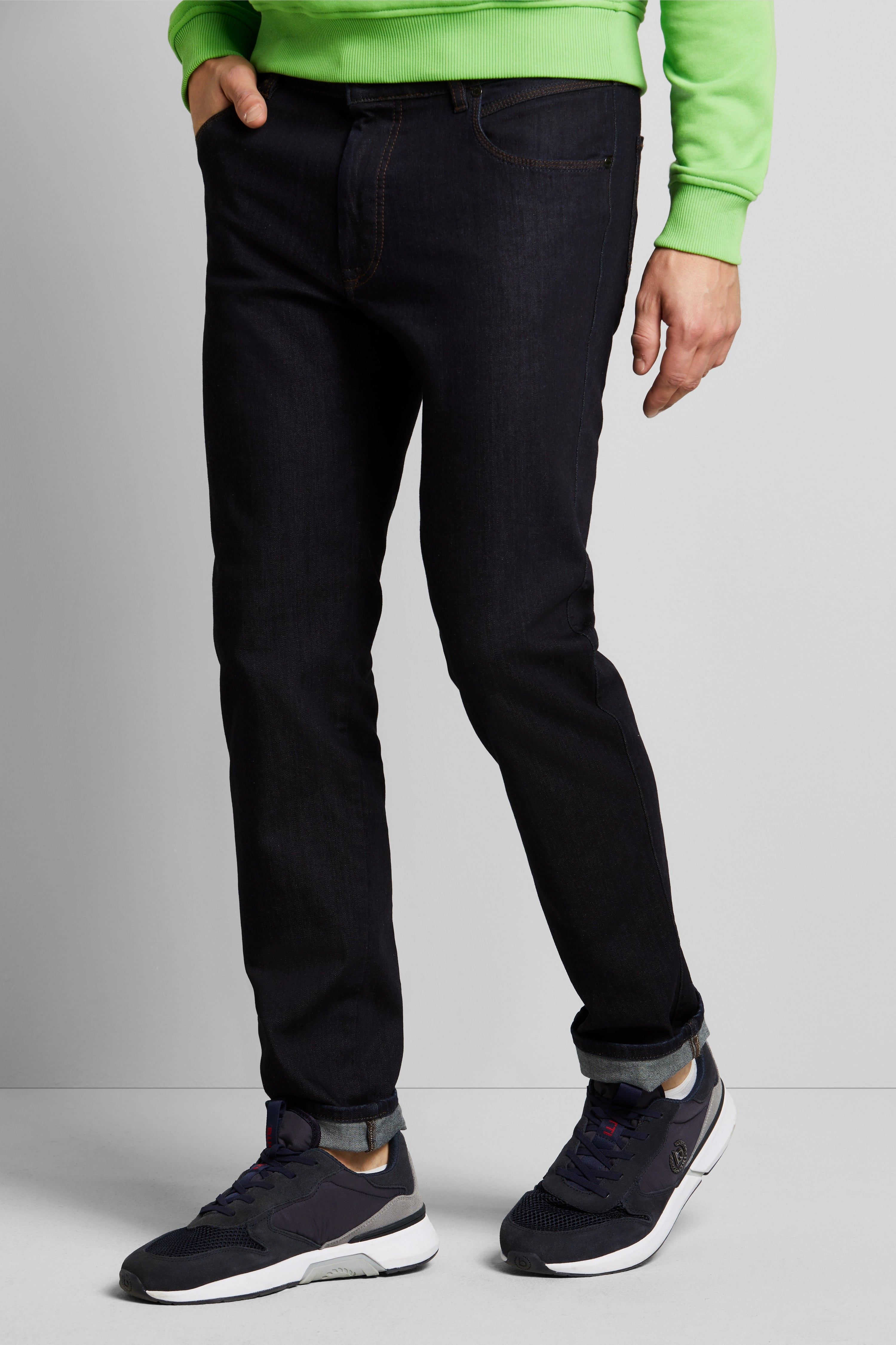 bugatti Modelbild: Dunkle Jeans, grüner Pullover, dunkle Sneaker