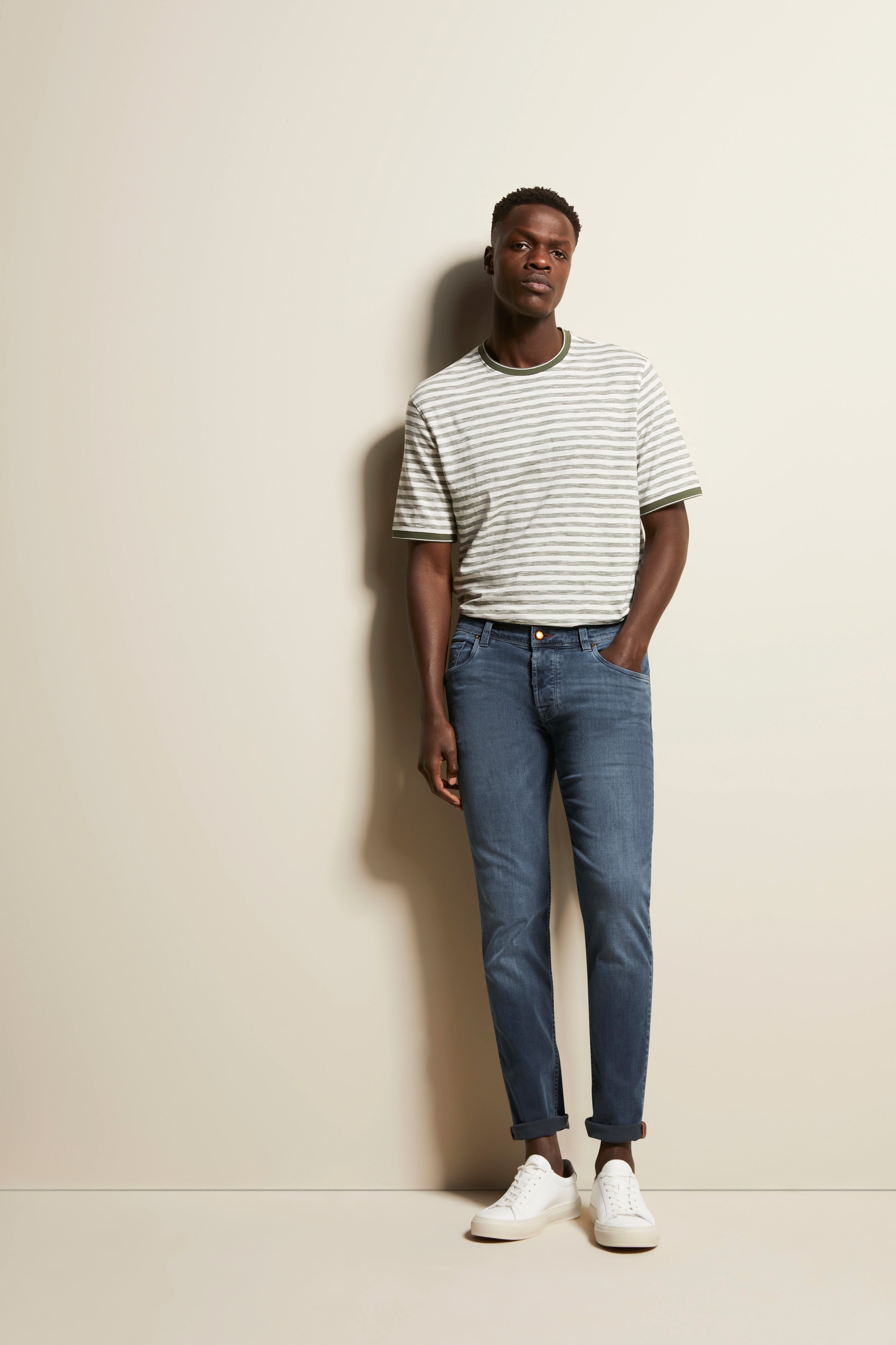 Gestreiftes T-Shirt in Grau-Weiß, blaue Jeans, weißer Sneaker