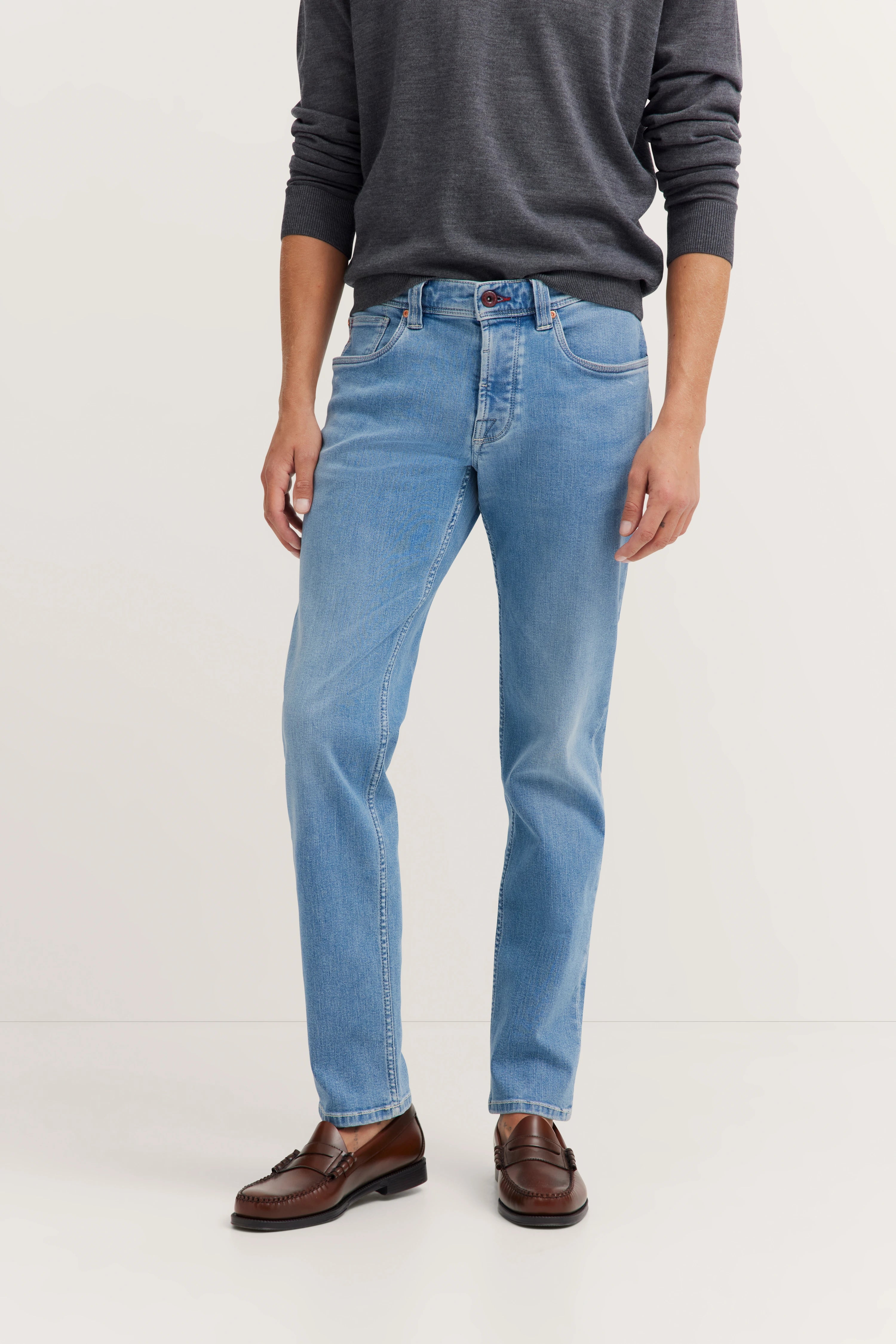 Grauer Pullover, blaue Jeans, braune Loafer