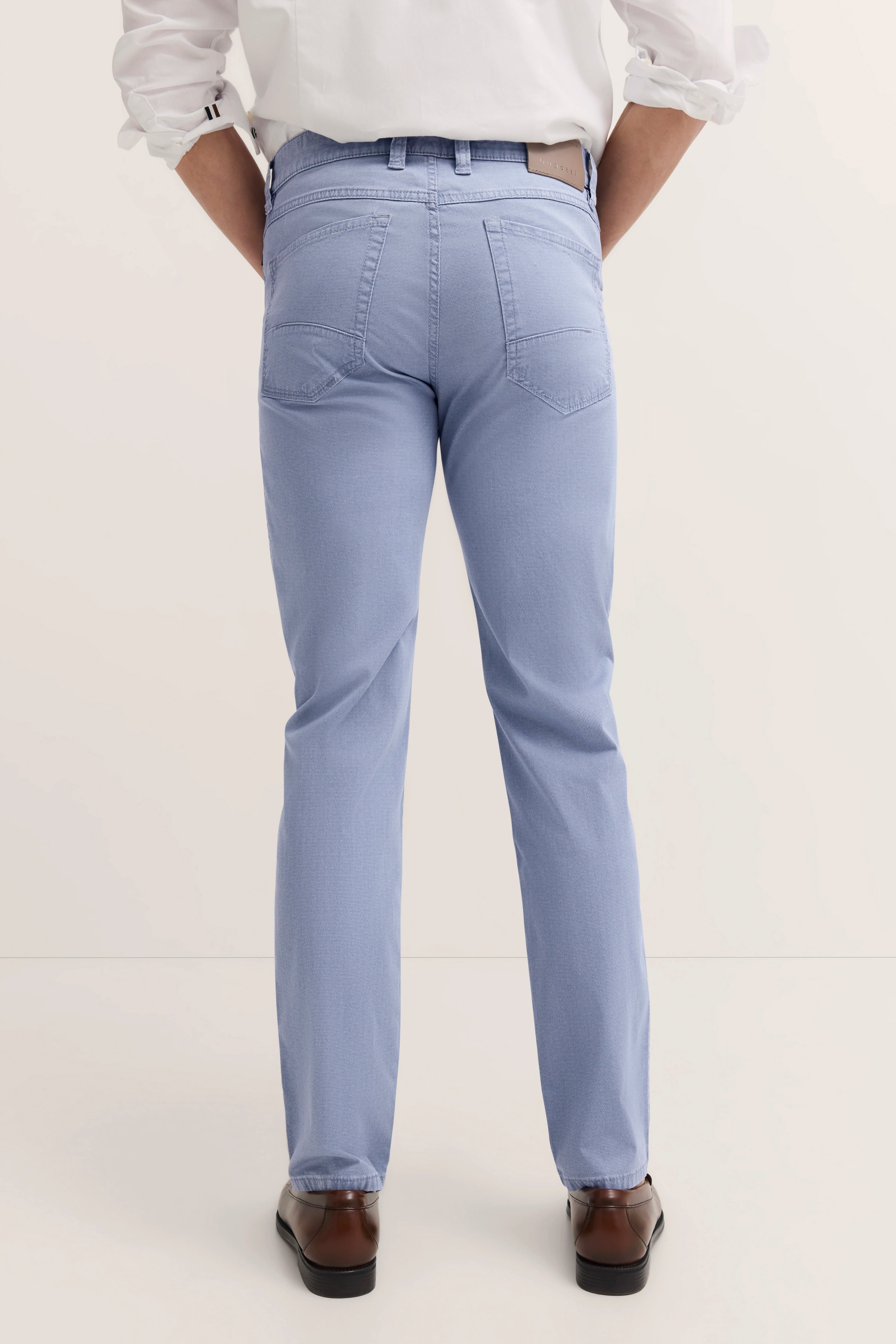 bugatti casual modelbeeld: lichtblauwe broek, wit overhemd, bruine schoenen, rugaanzicht.