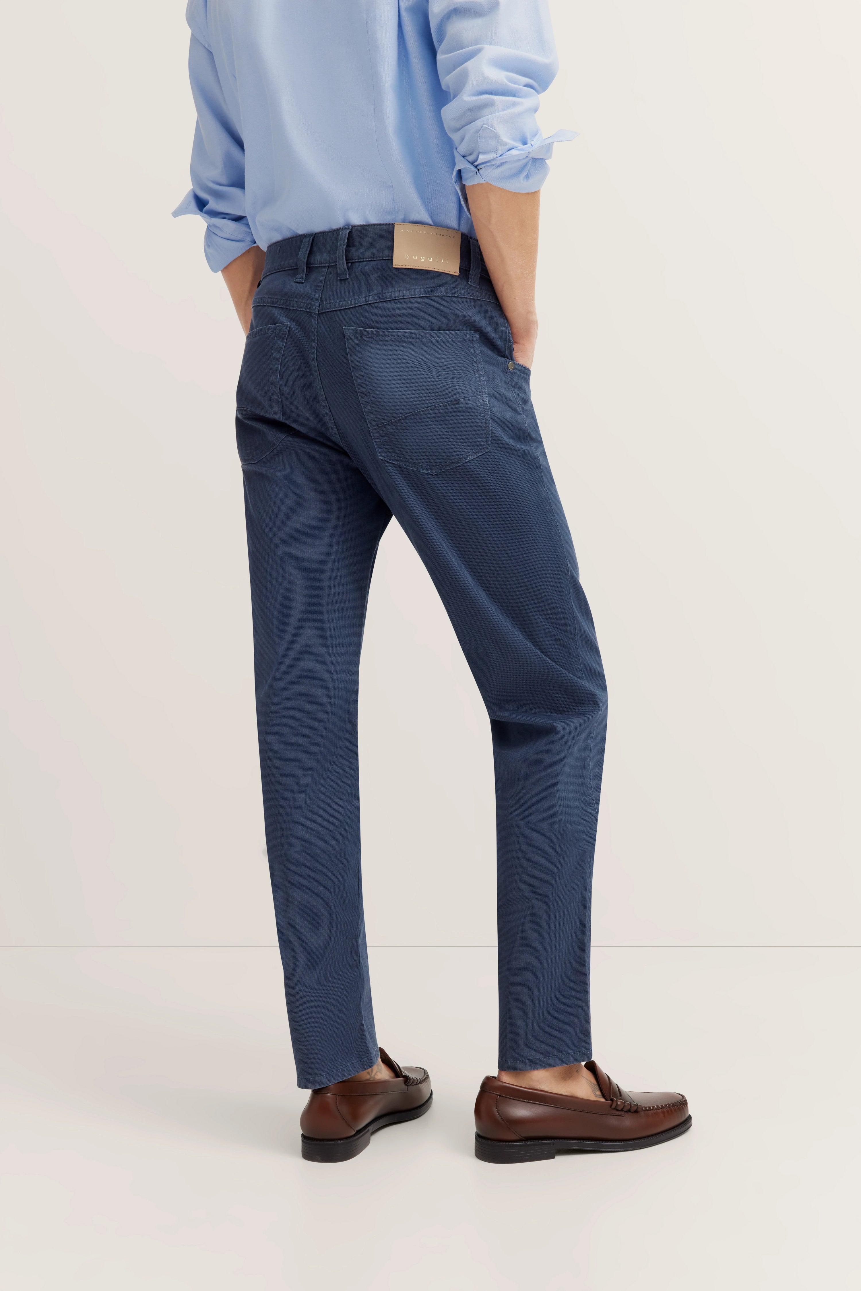Blauwe bugatti outfit, overhemd en broek, model van achteren, ontspannen houding.