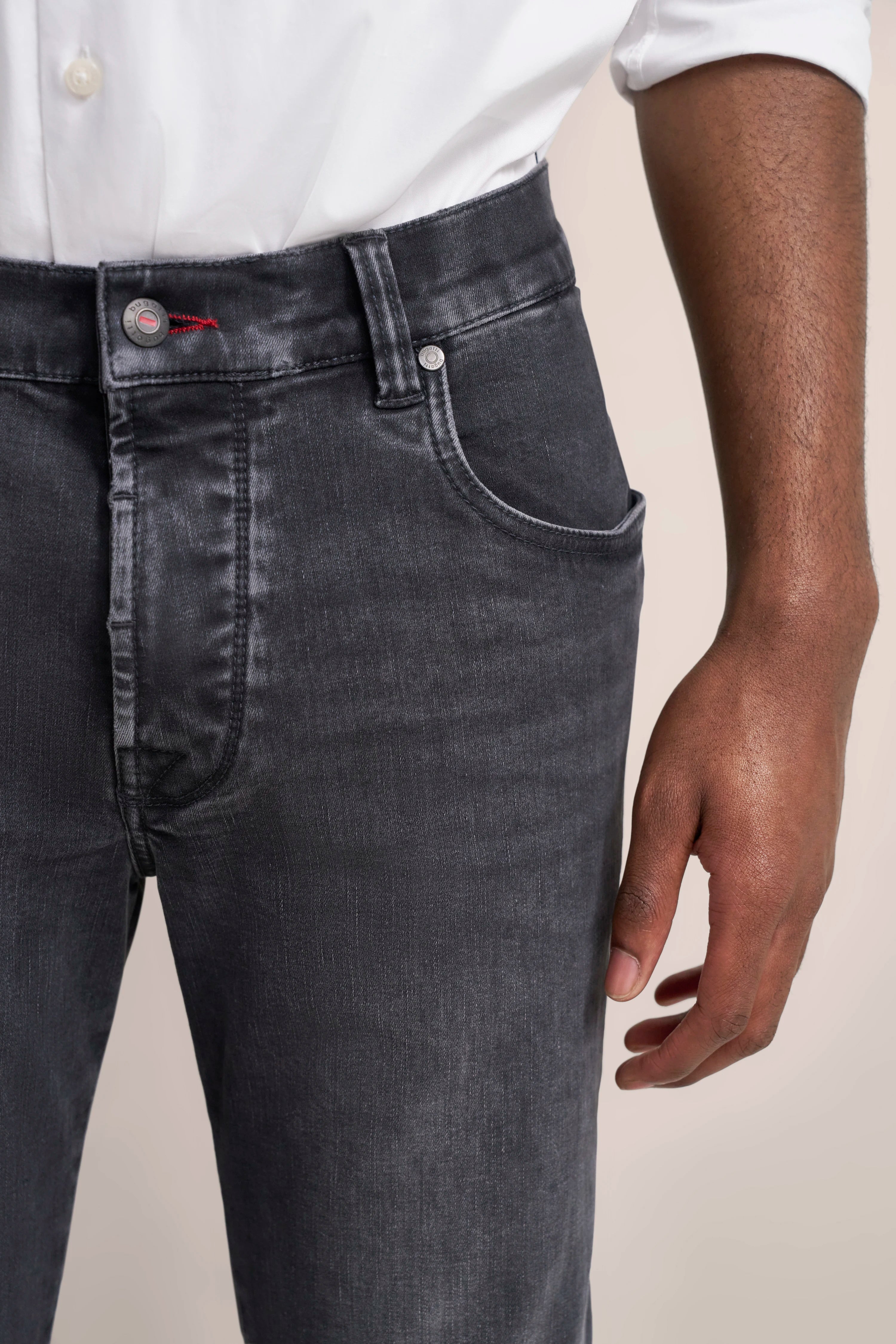 Dunkelgraue Jeans von bugatti, Nahaufnahme, legeres Modelbild, weiße Hemdmanschette.