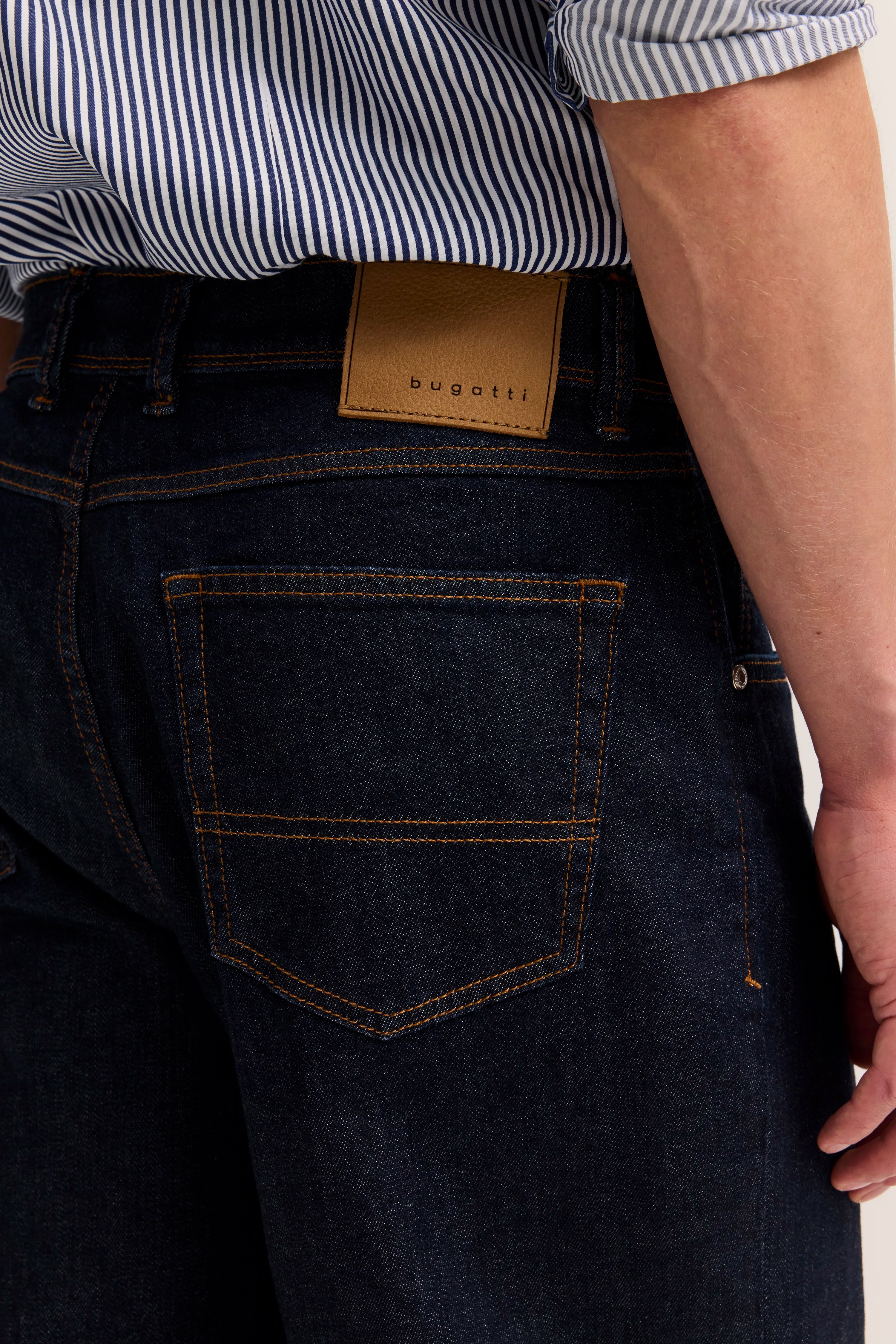 Dunkelblaue Jeans von bugatti mit gestreiftem Hemd, Detailansicht der Gesäßtasche.