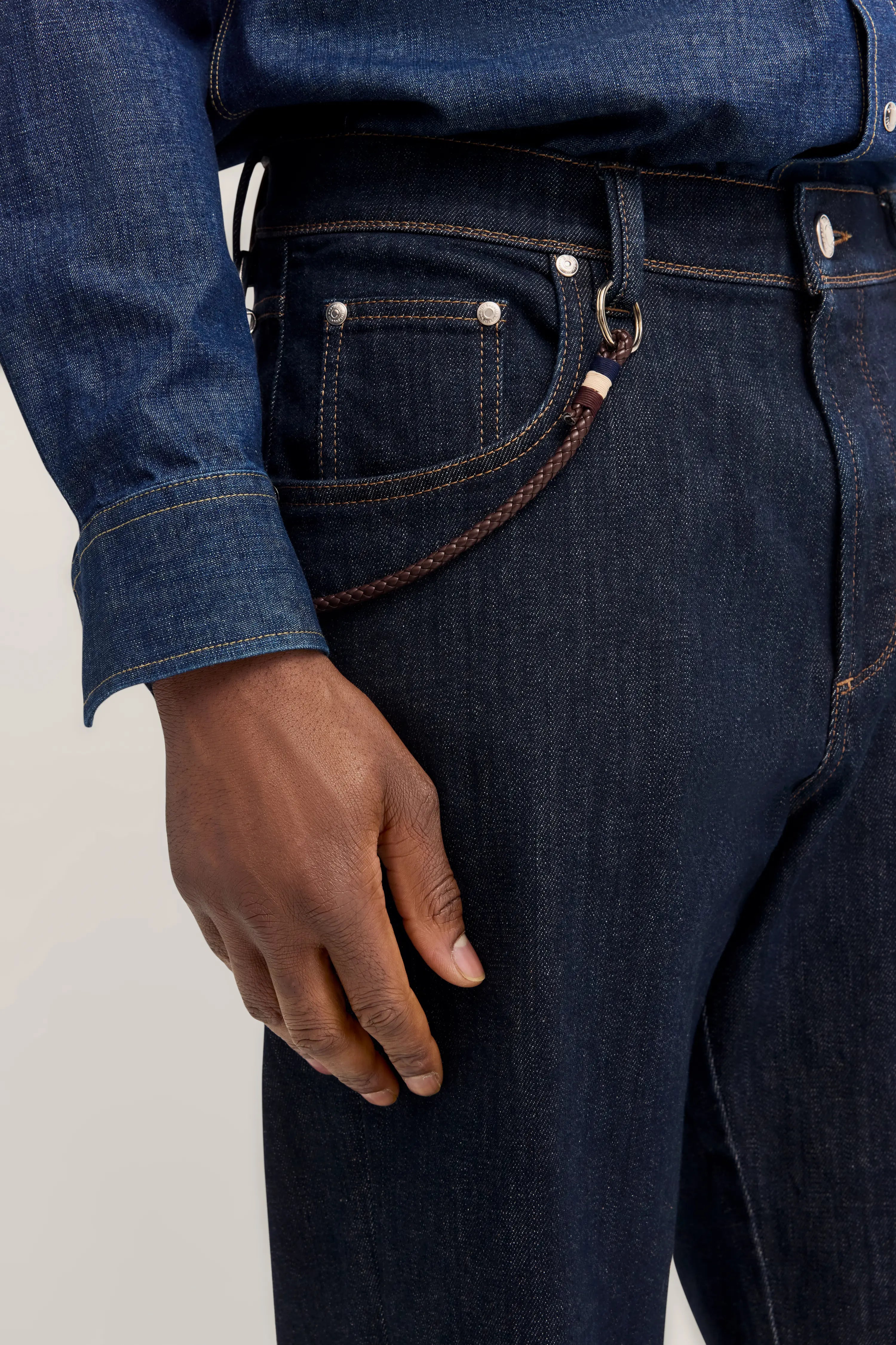 Dunkelblaues Jeans-Outfit von bugatti, Detailaufnahme mit brauner Kordel.