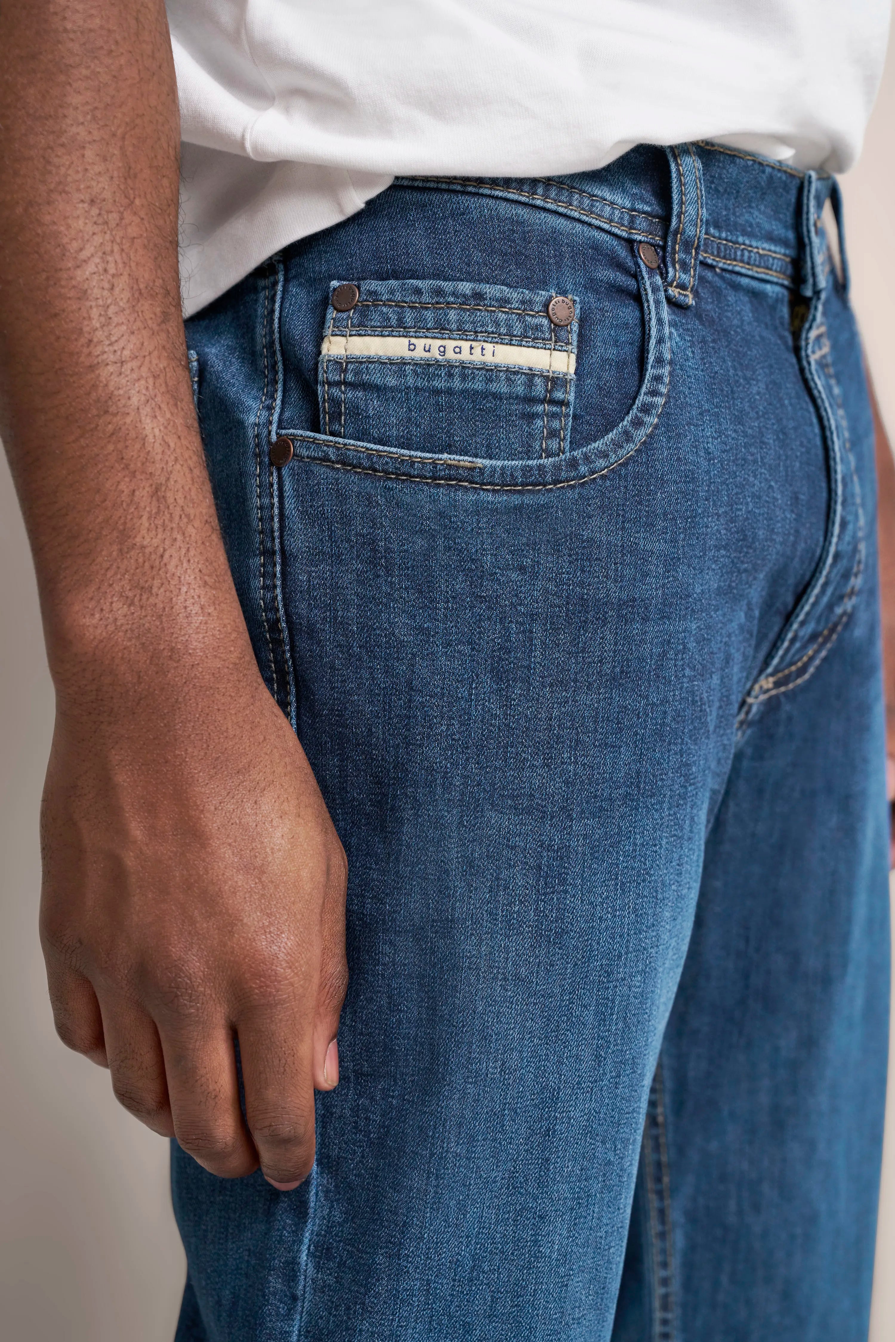 bugatti Jeans in Blau, Detailaufnahme mit weißem T-Shirt, entspannt, hochwertig und stilvoll.