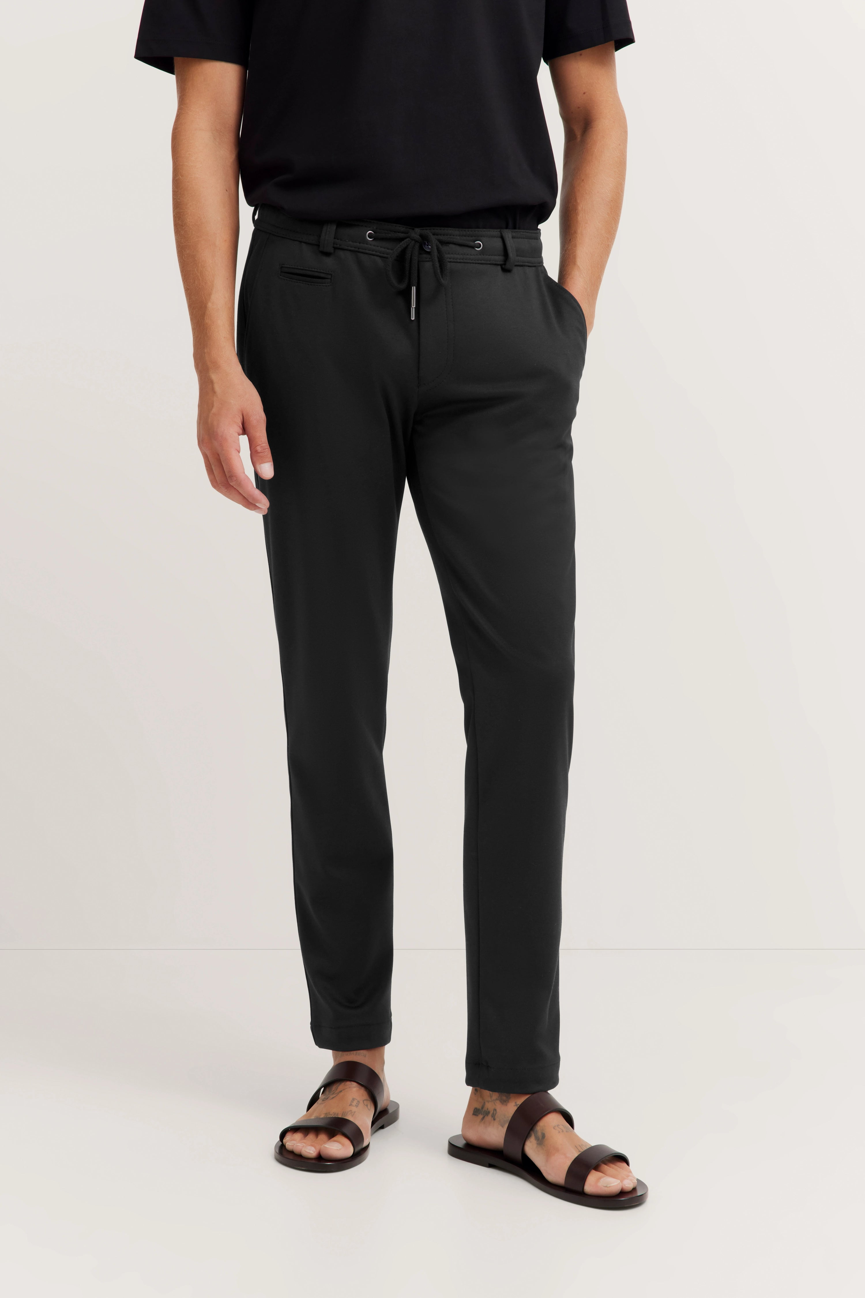 Black drawstring pants and sandals, casual style, model standing, bugatti.