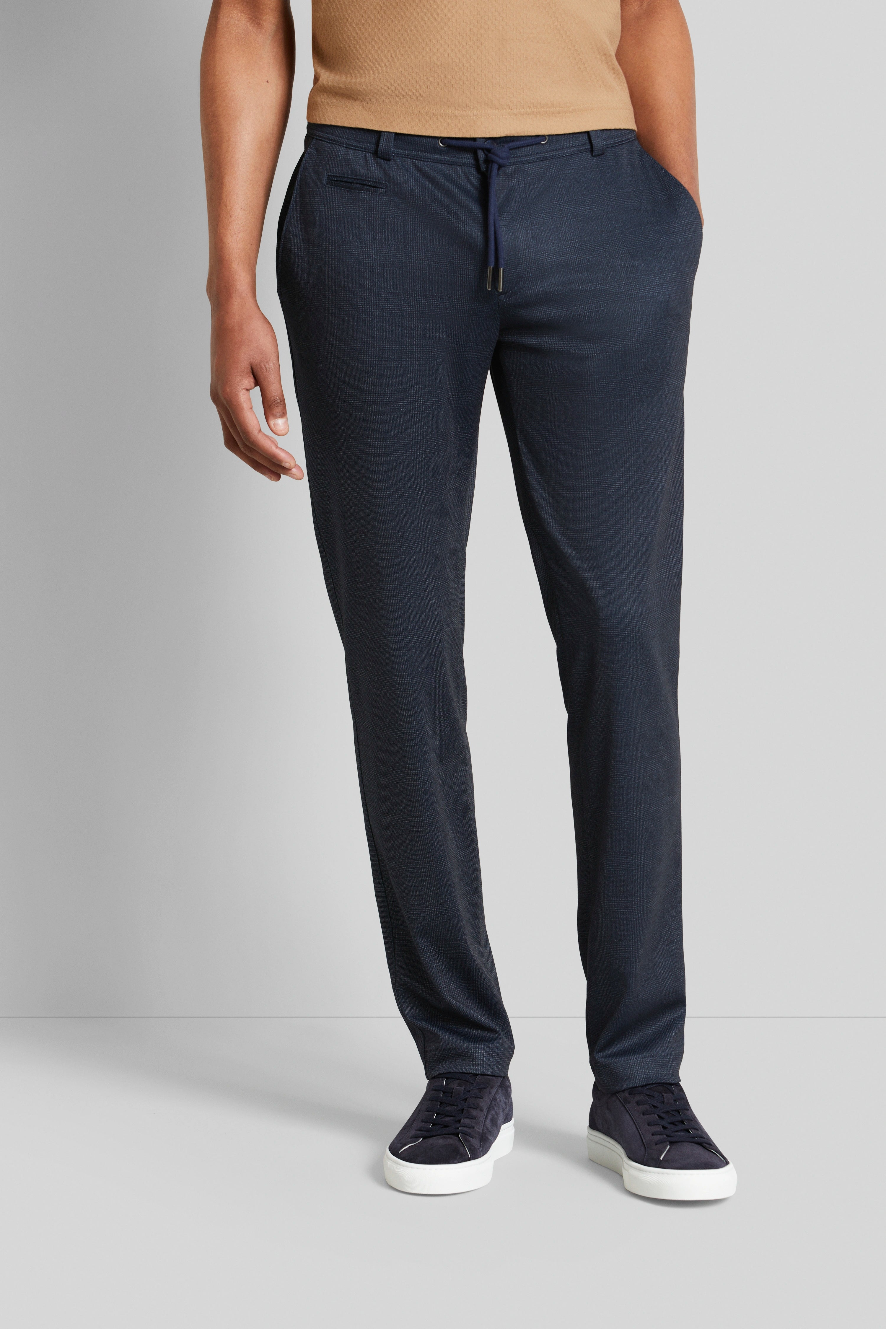 Donkerblauwe bugatti broek en sneakers, casual modelbeeld, ontspannen houding.