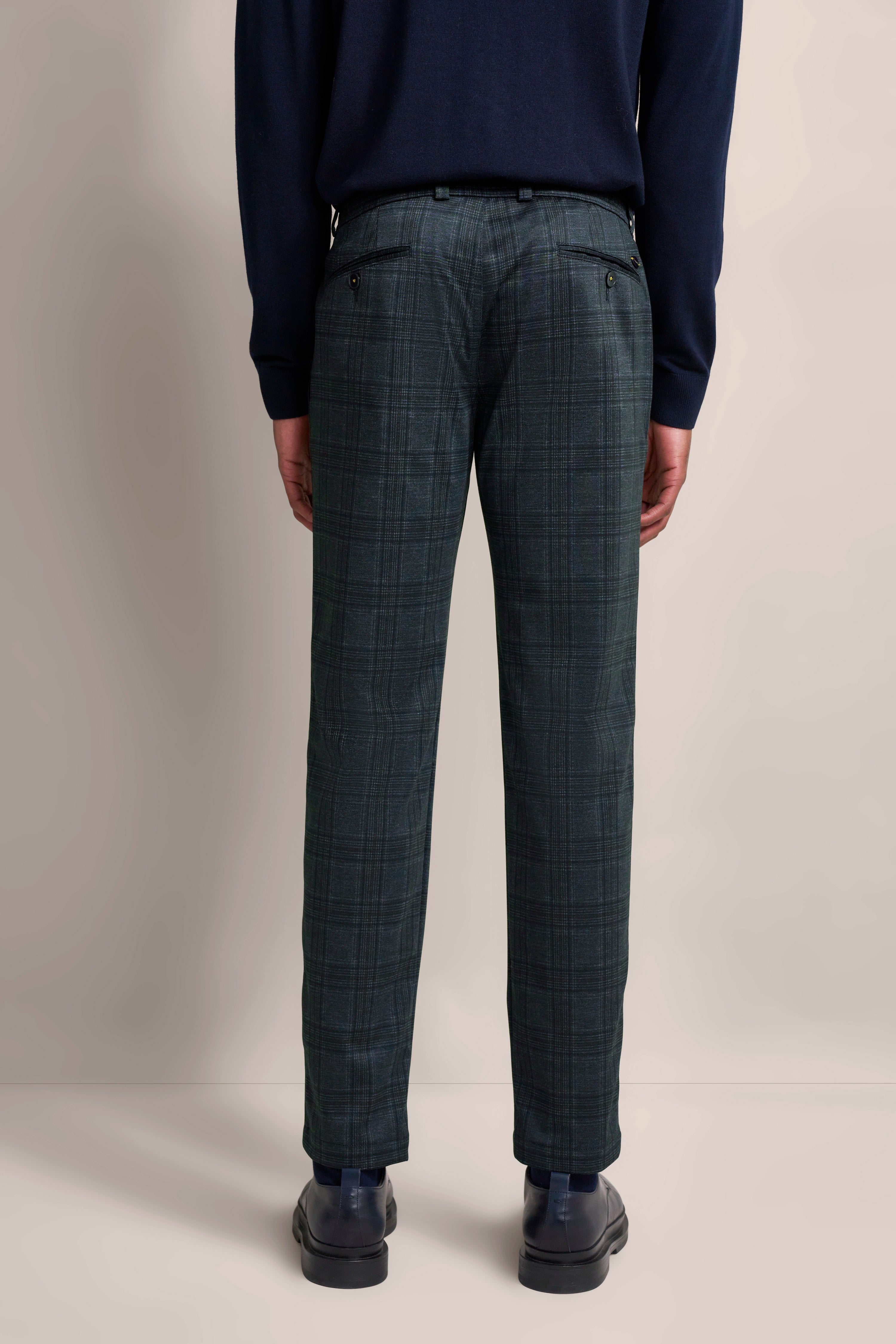 Blaues Oberteil, karierte Hose in Grau-Grün, legeres Modelbild, Rückansicht.