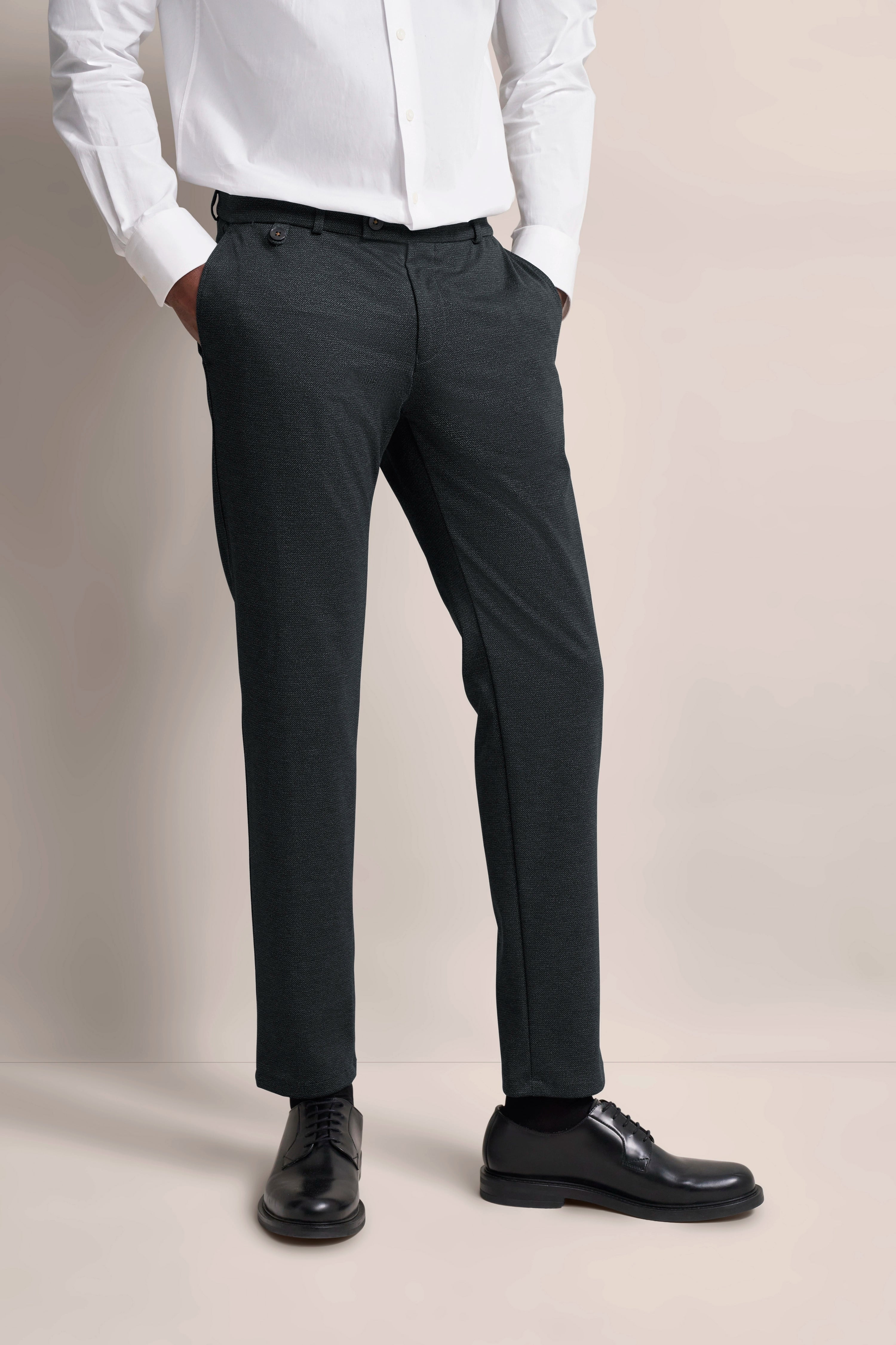 Schwarze bugatti Hose mit weißem Hemd, Modelbild, lässige Pose, zeitlose Eleganz.
