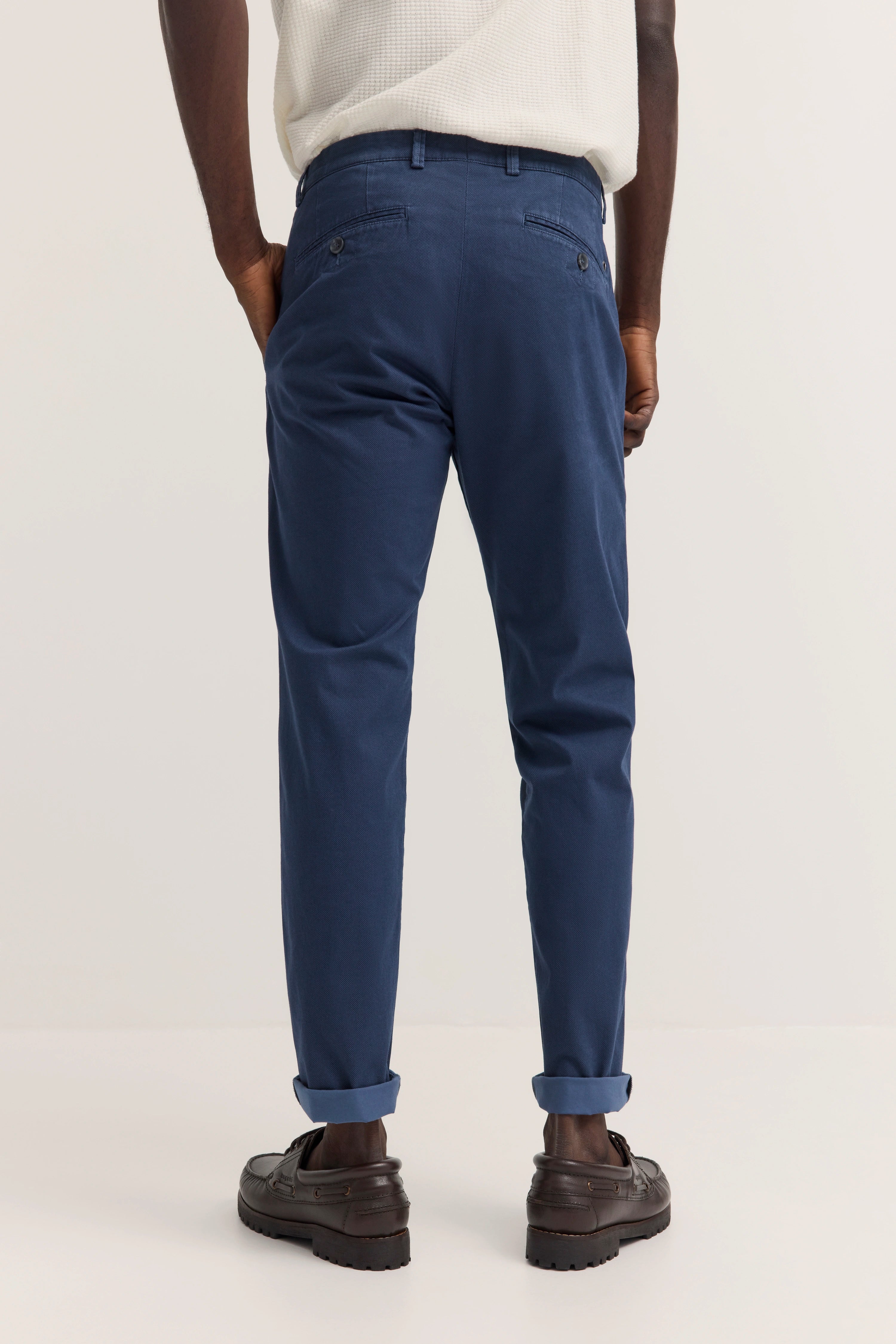 Bugatti Chino in Blau, lässig präsentiert, kombiniert mit weißem Shirt, legeres Modelbild von hinten.