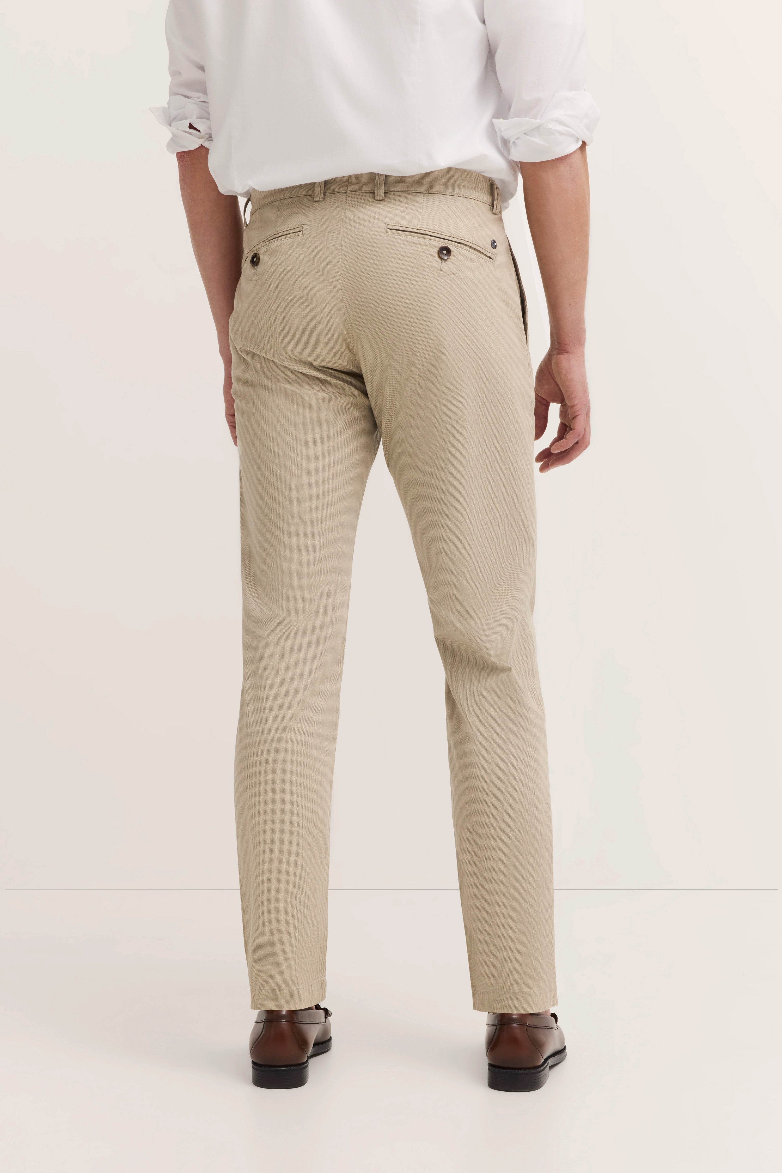 Beige bugatti Hose mit Bügelfalte, Model von hinten, weißes Hemd, braune Schuhe.