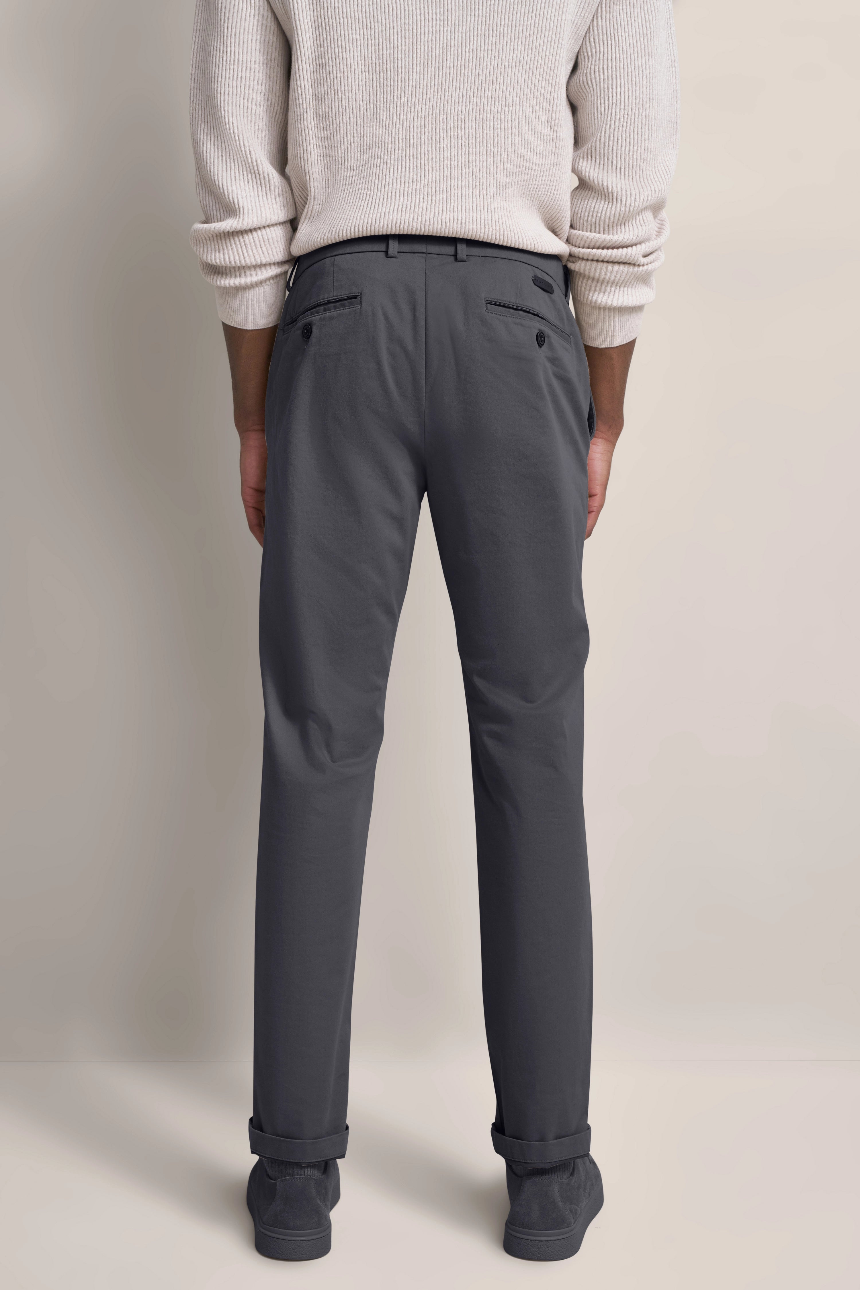 Büstenbild: Graue Chinohose, weißer Pullover, lässig, Rückansicht.
