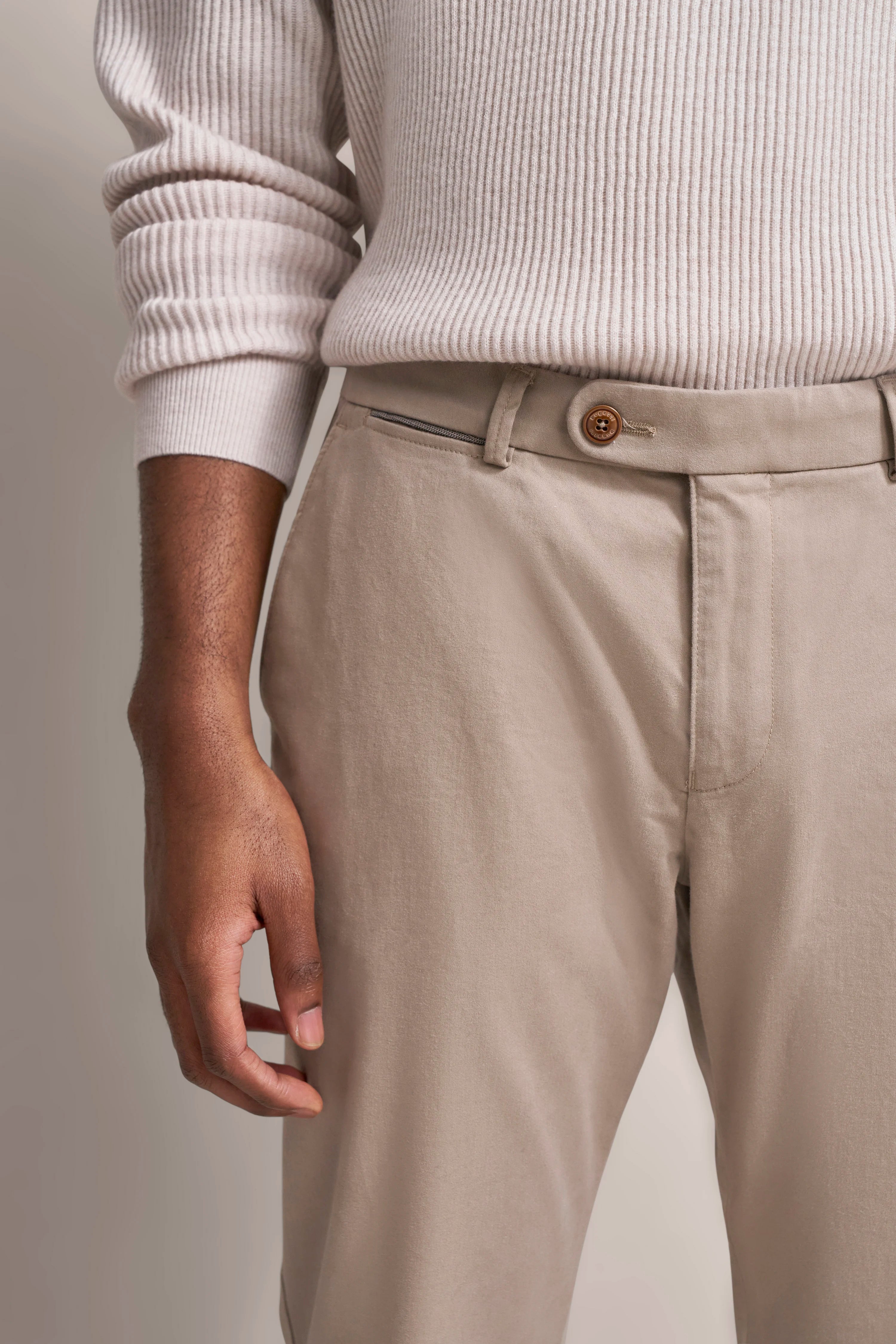 Beigefarbene Hose mit beigem Strickpullover, legeres Detailbild, bugatti Stil.