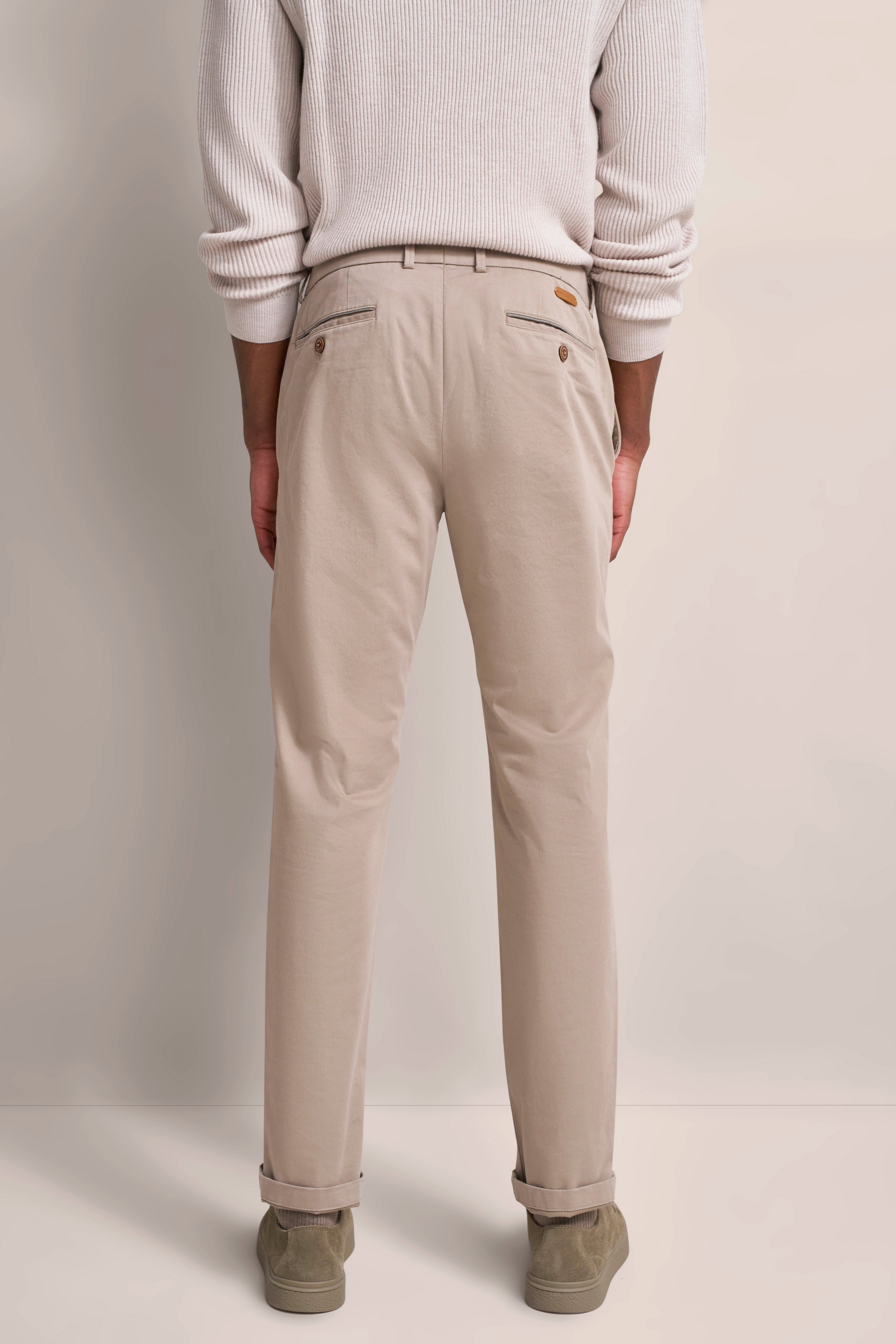 Beige Chinohose von bugatti, getragen von einem Model im legeren Outfit von hinten.