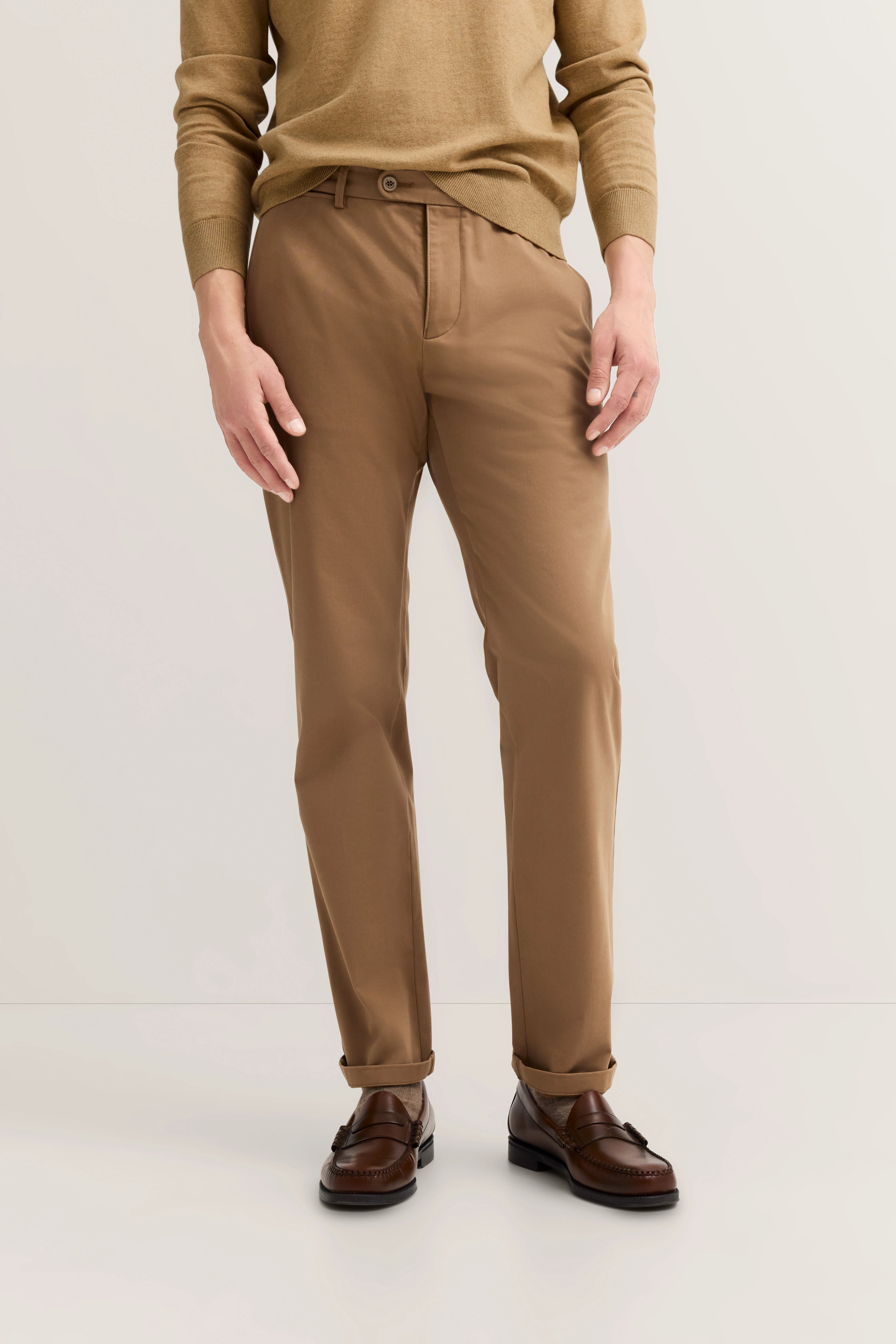 Braune Chino mit beigem Pullover, legeres Modelbild, entspannte Pose, bugatti Stil.