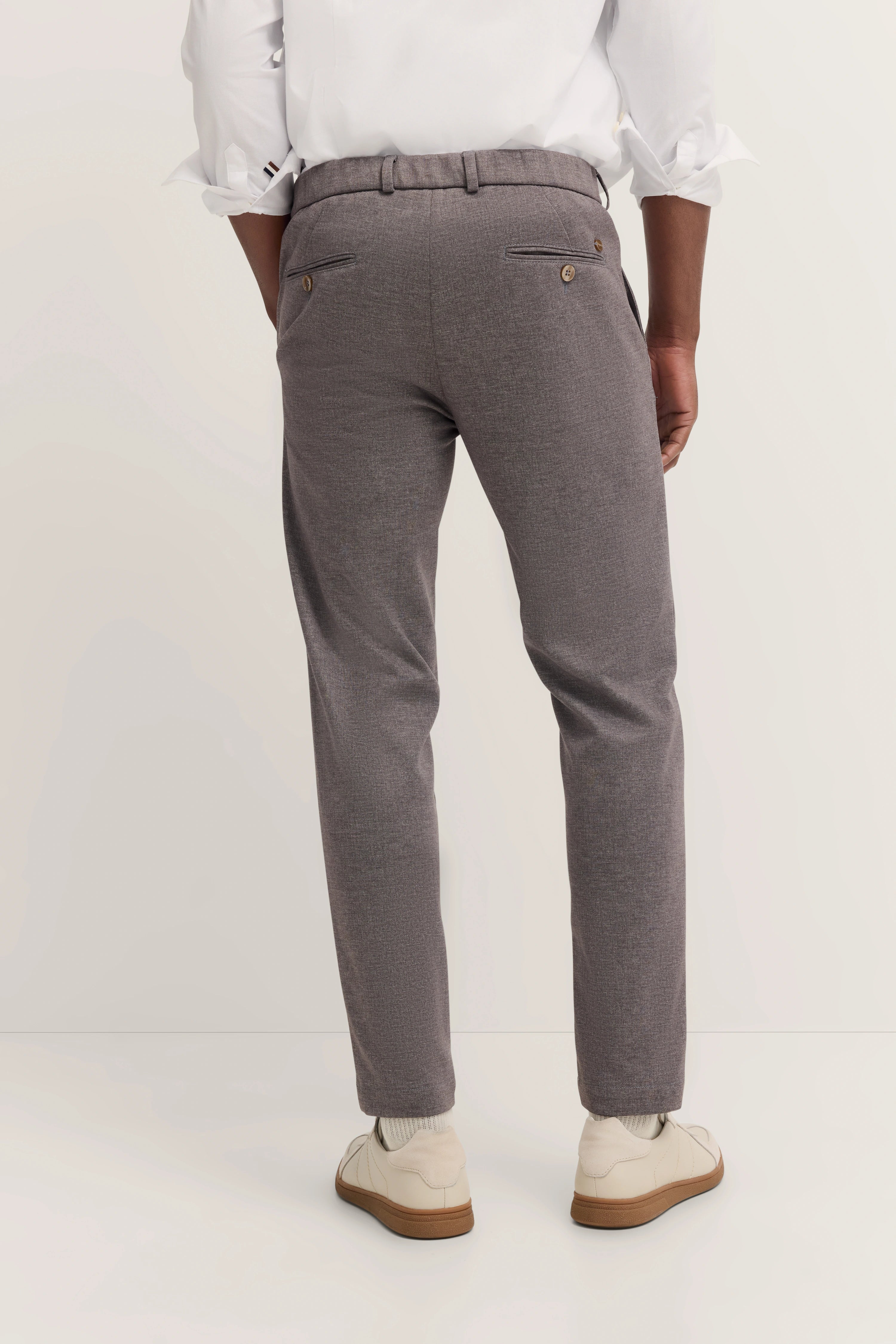 Graue bugatti Hose, weißes Hemd, Model von hinten, leger, weiße Schuhe.
