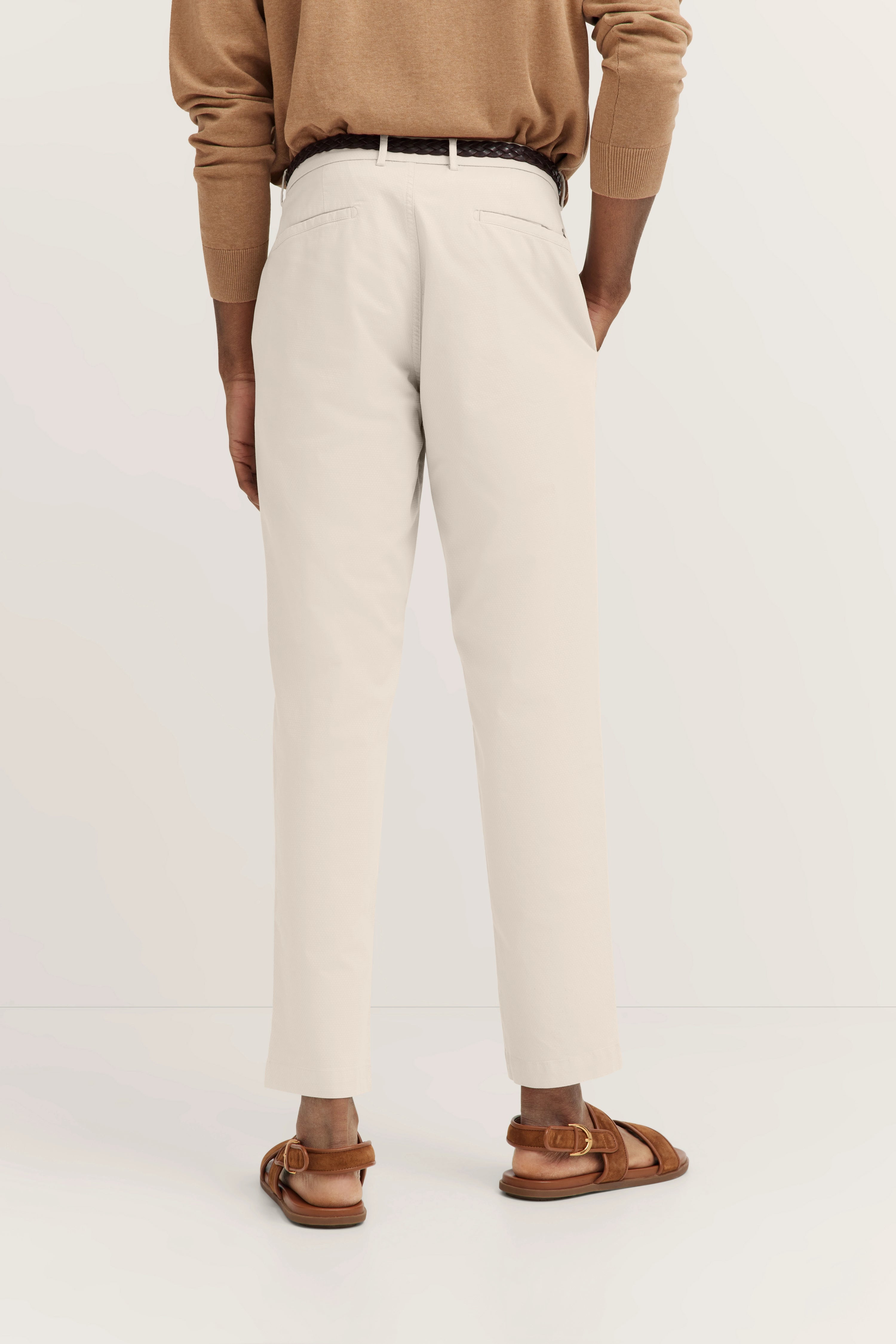 Beige broek en bruine trui van achteren, casual modelbeeld, stijlvolle sandalen.