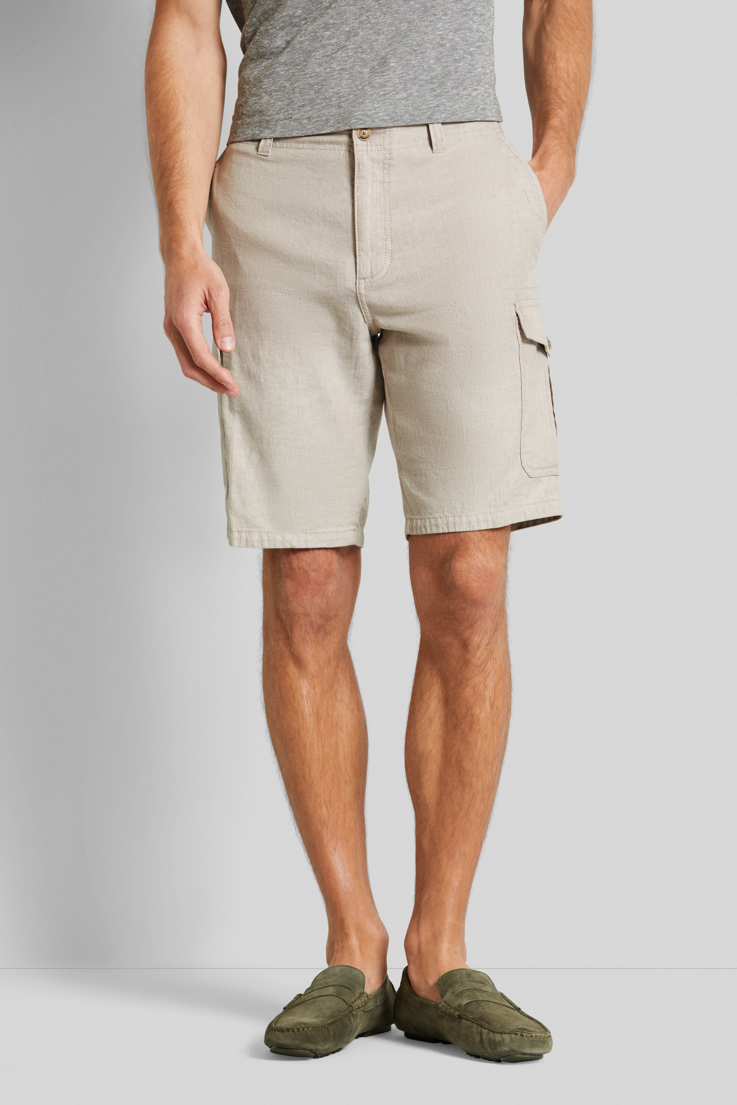 Beige Shorts und graues T-Shirt, legeres Modelbild, entspanntes Posing.