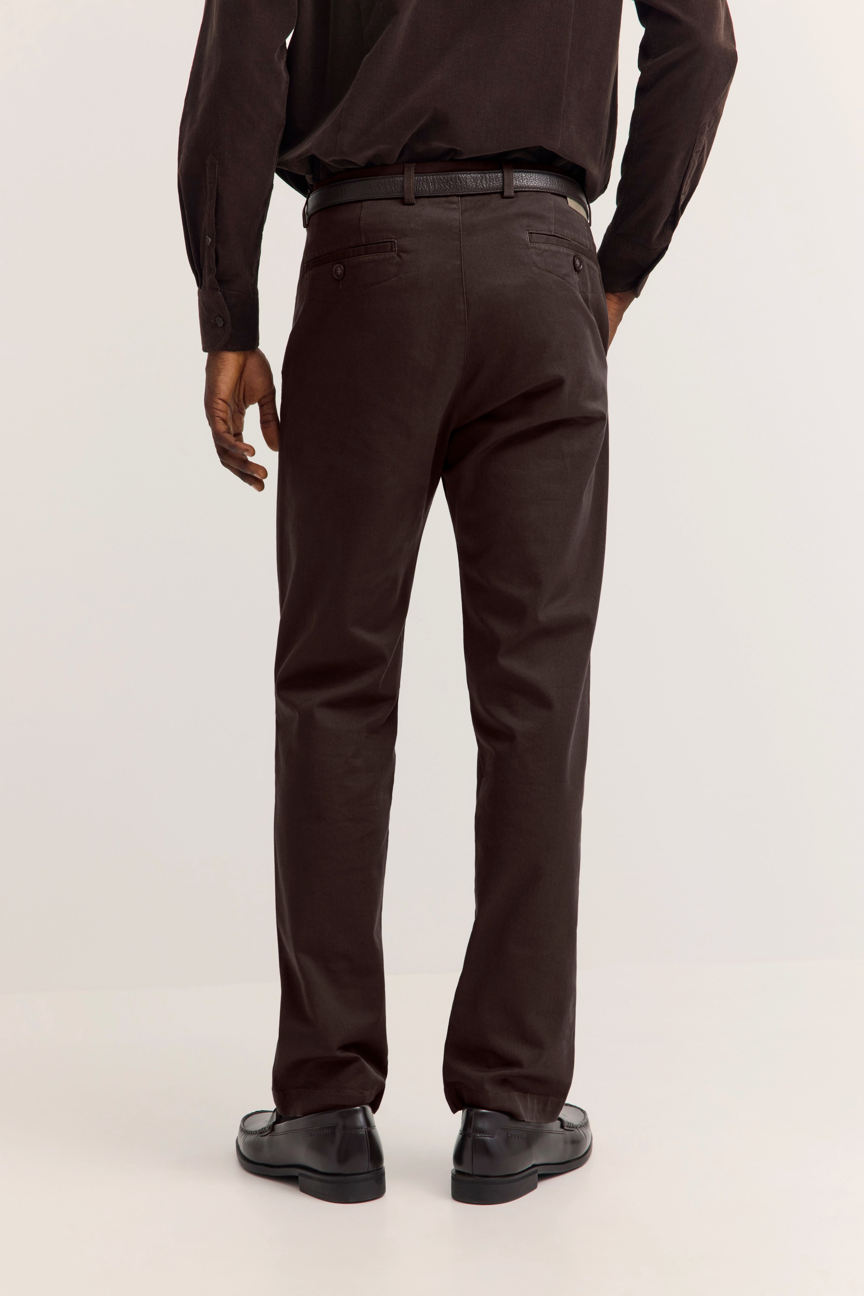 Braune Cordhose, Rückansicht, legeres Modelbild, schwarze Lederschuhe.